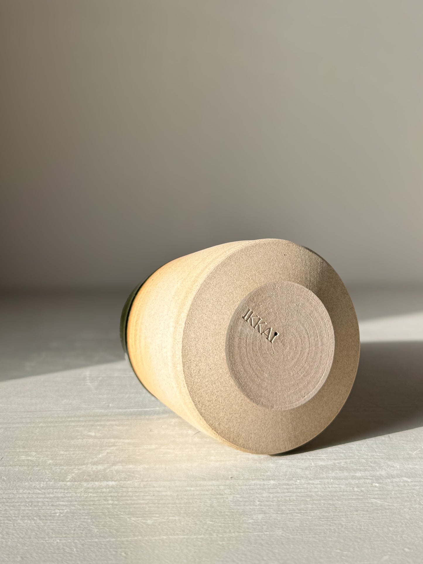 Ceramic Christmas Tree – Mori #01 lying on its side, showcasing the smooth, hand-thrown base with stamped branding.