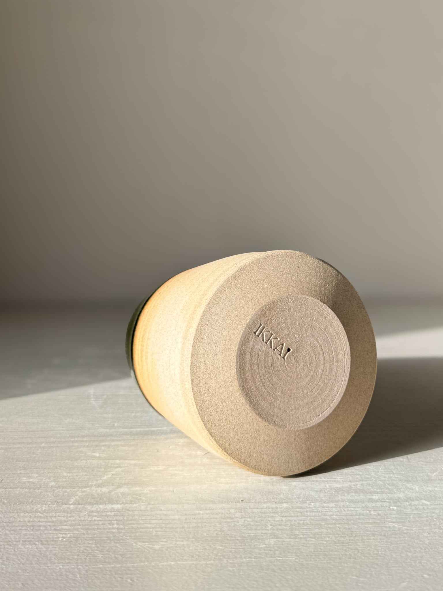 Ceramic Christmas Tree – Mori #01 lying on its side, showcasing the smooth, hand-thrown base with stamped branding.