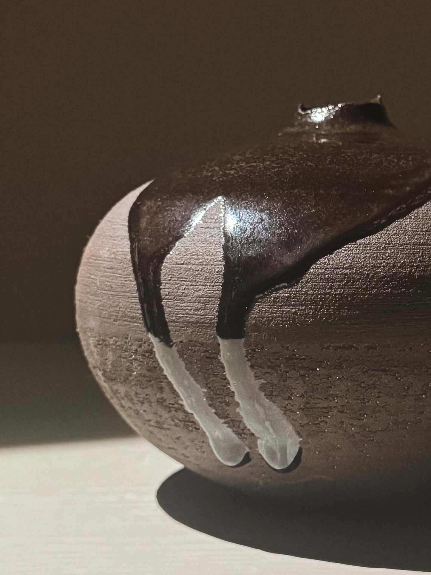 Close-up of Orb Vase – Kuro Black #01 showcasing unique glaze patterns and sculptural form.