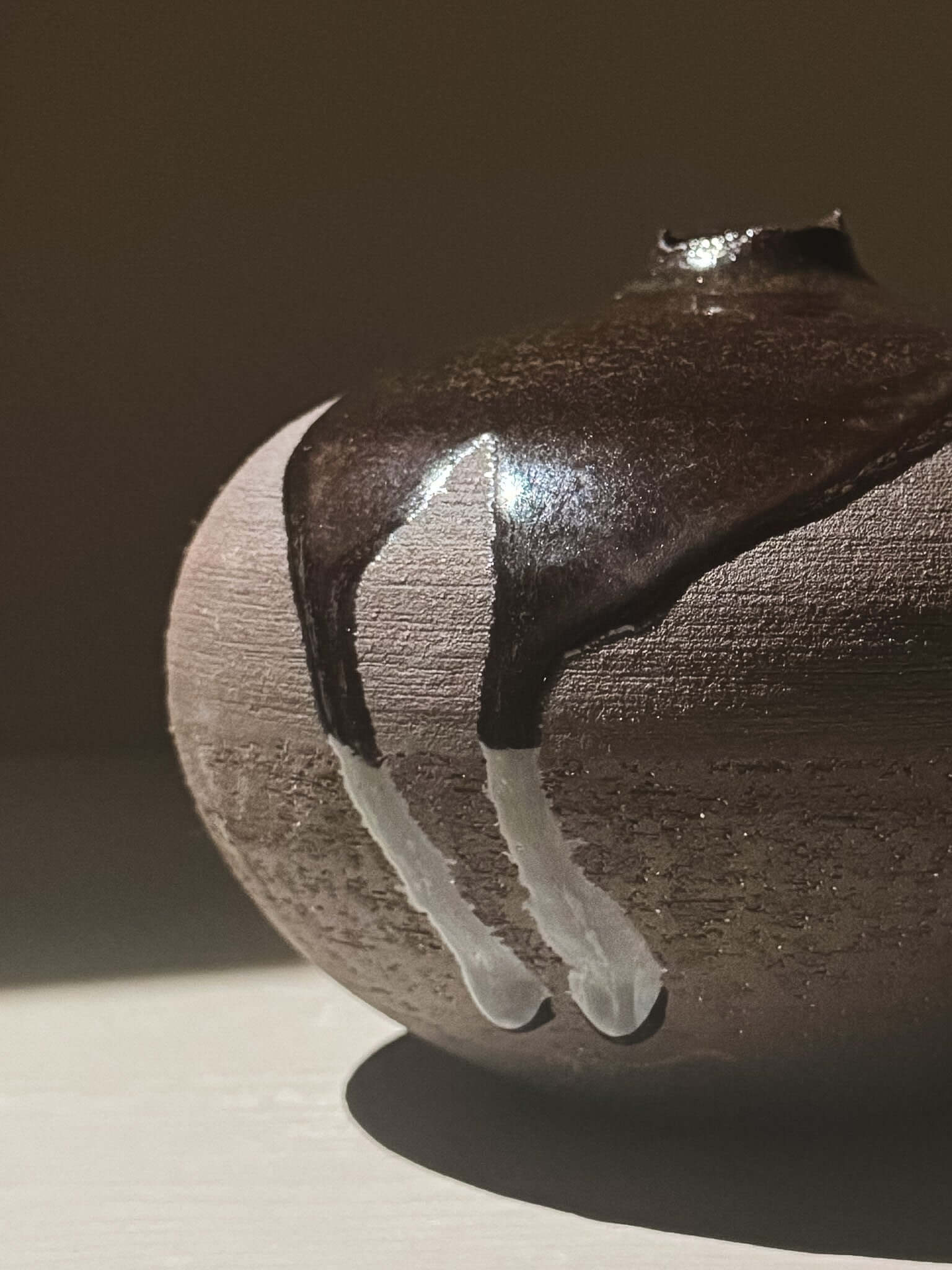 Close-up of Orb Vase – Kuro Black #01 showcasing unique glaze patterns and sculptural form.