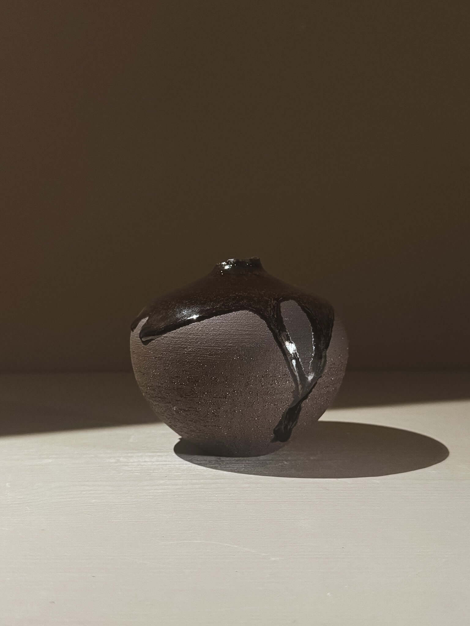 Unique Orb Vase – Kuro Black #02 with spherical form and black glaze, showcasing gentle drips and sculptural design.