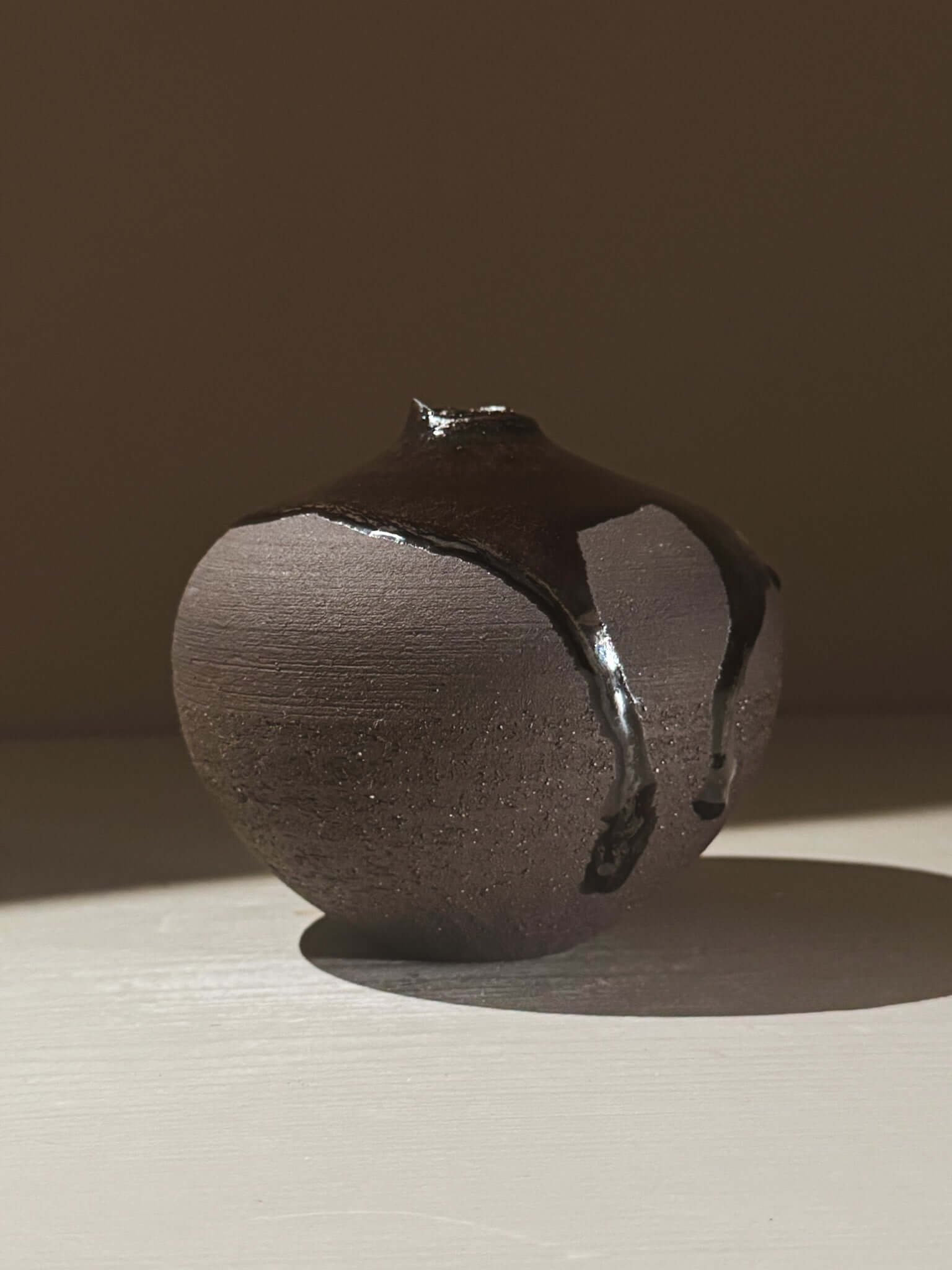 Orb Vase – Kuro Black #02 with unique glaze drips creating organic patterns on a rounded sculptural form.