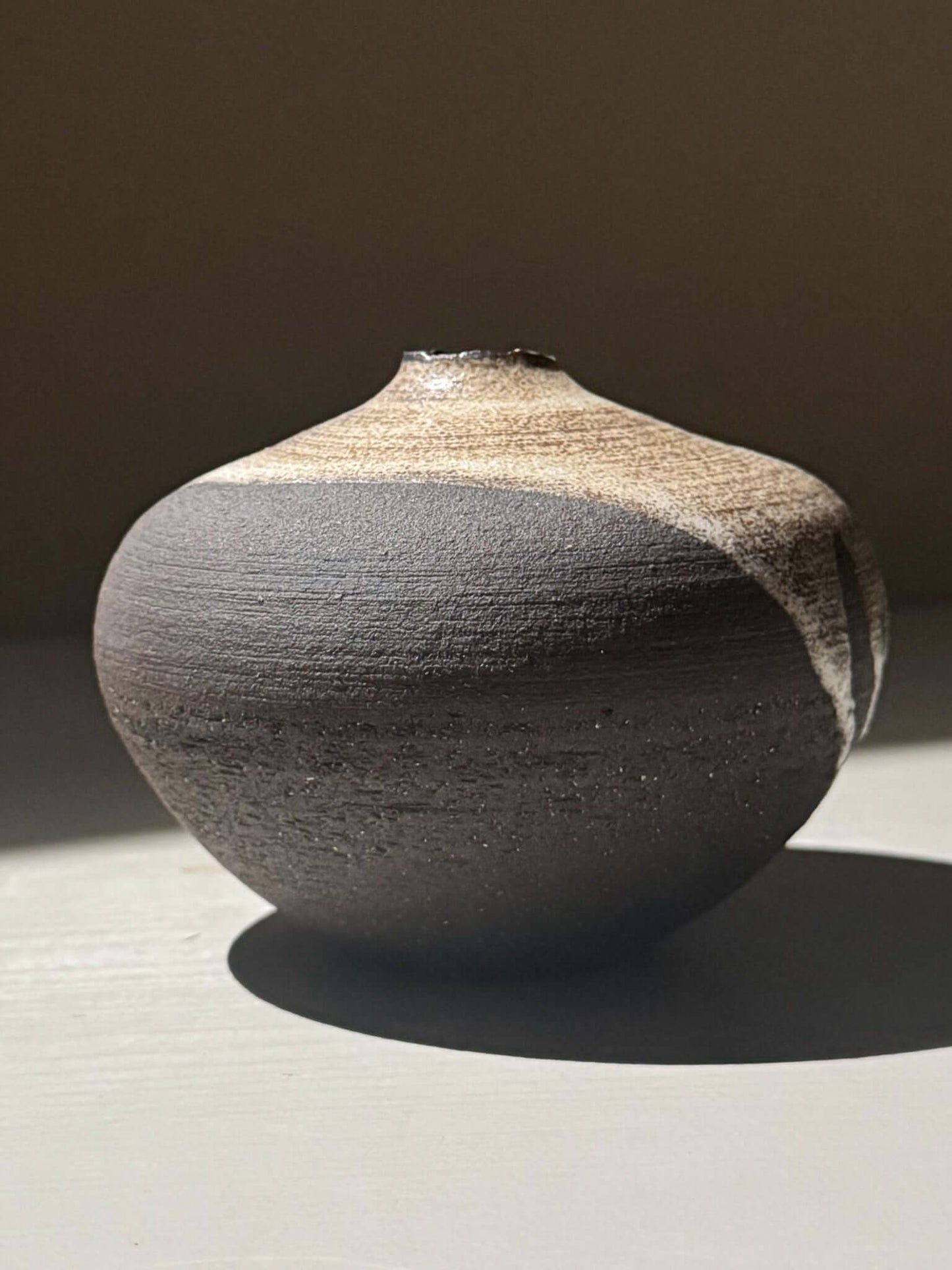 Orb Vase – Matt Clear, a unique rounded ceramic vase with natural glaze patterns and a sculptural presence.
