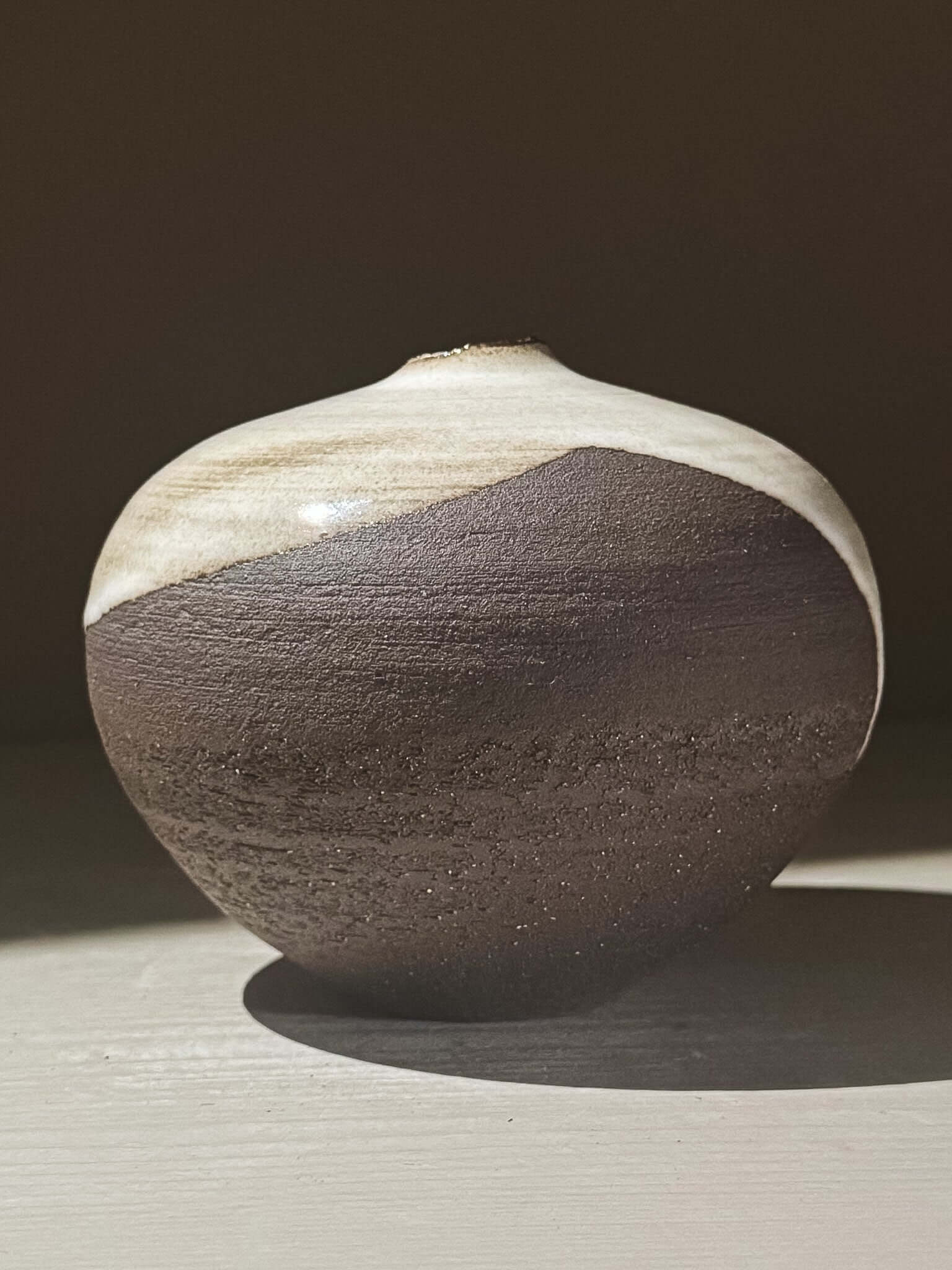 Orb Vase – Yuki Black #04 displayed against a neutral backdrop, showcasing its unique clay and glaze details.