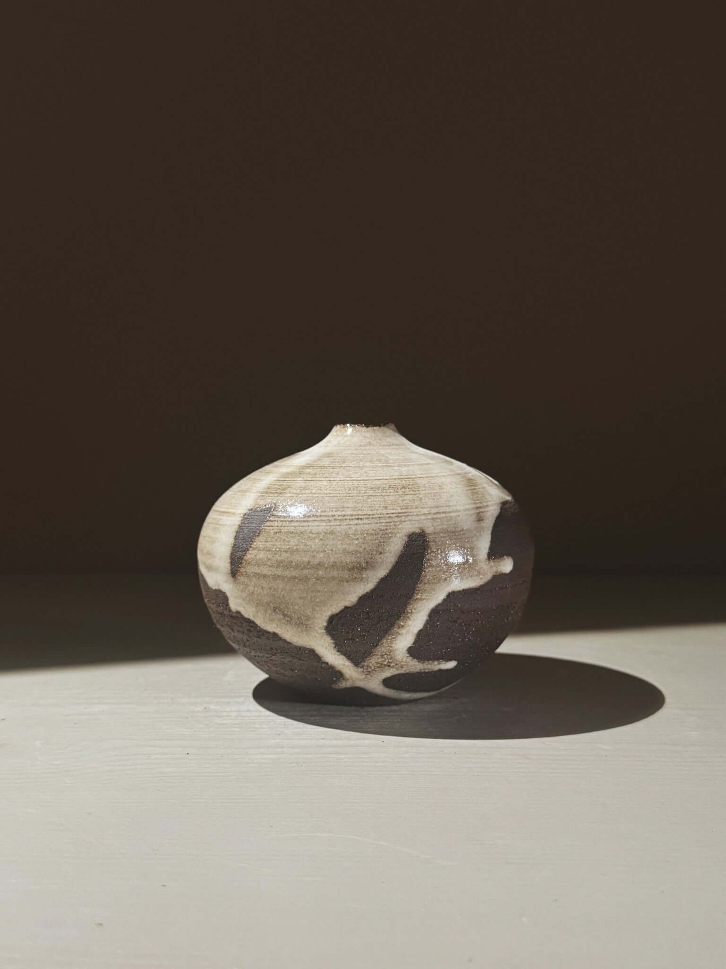 Orb Vase – Yuki Black #07 with unique glaze patterns and soft spherical form on a neutral background.