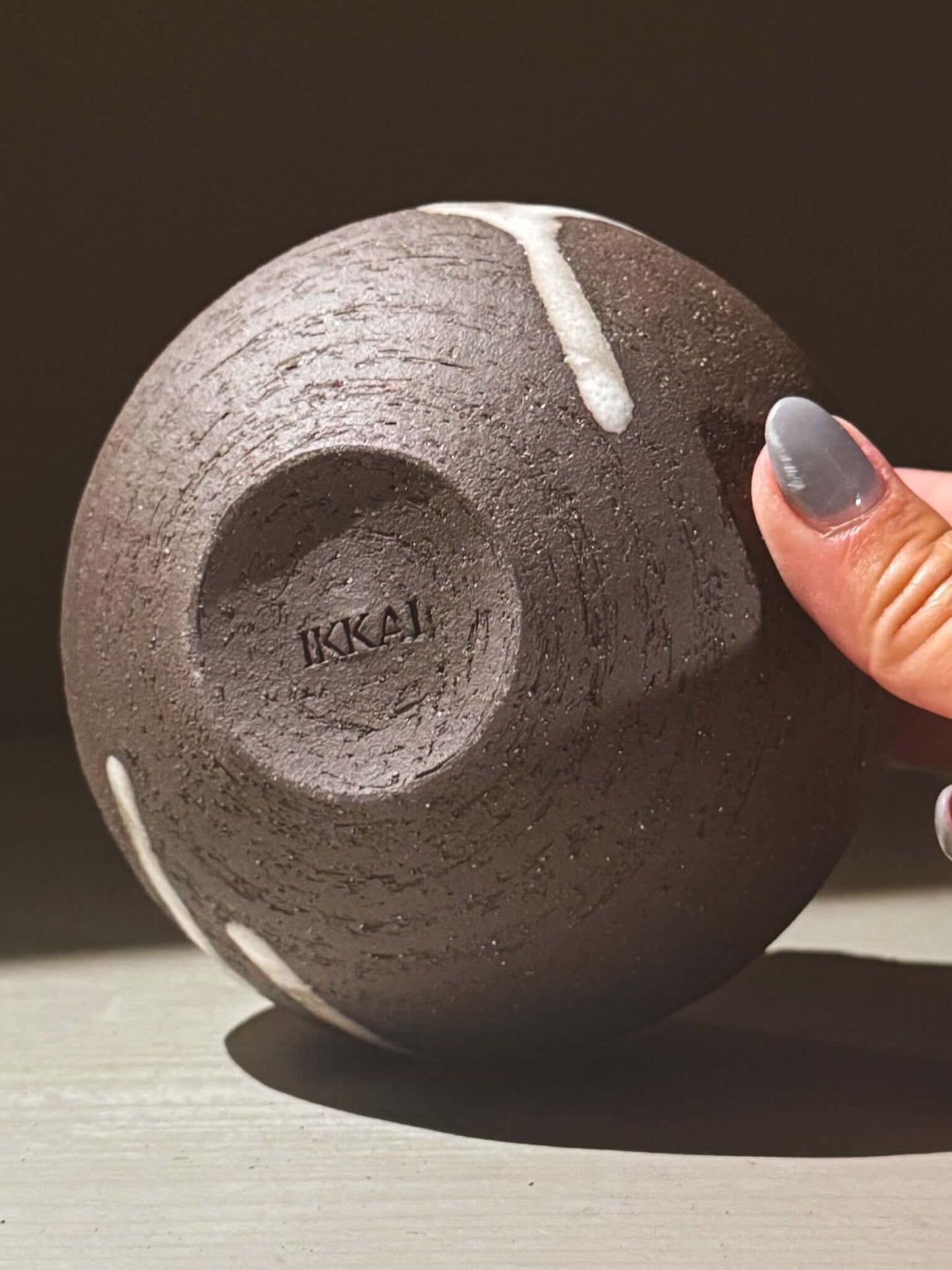 Orb Vase – Yuki Black #08 showing unique glaze patterns and rounded shape, held in hand.