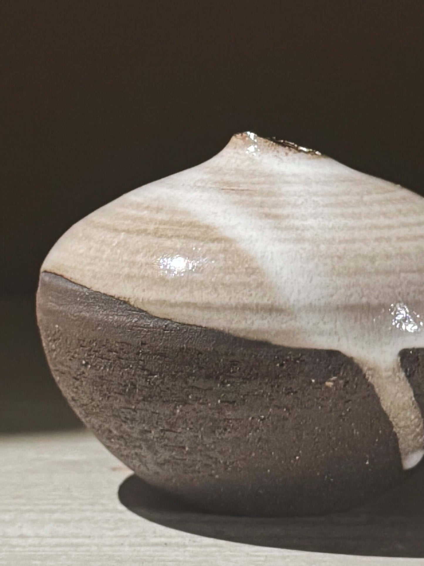 Orb Vase – Yuki Black #11 with unique glaze and sculptural form, displaying gentle drips and organic patterns on the rounded vessel.