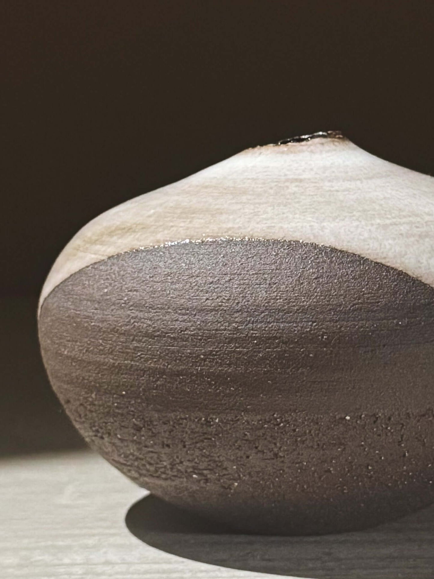 Orb Vase – Yuki Black #12 with unique glaze patterns and soft spherical form, showcasing artisanal craftsmanship in rounded vessels.