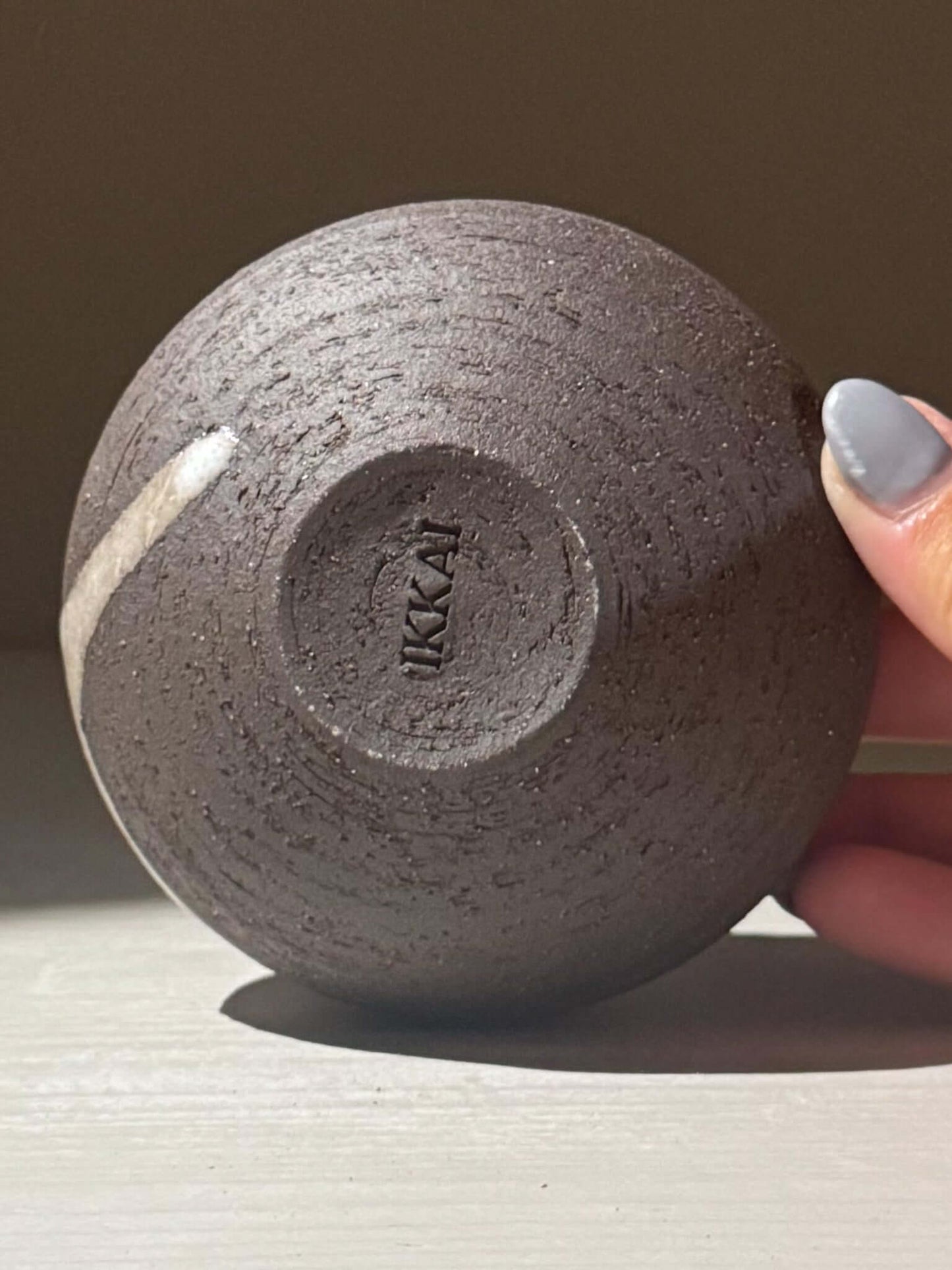 Bottom view of Orb Vase – Yuki Black #13 showing textured clay and unique glaze pattern, displaying the handcrafted nature of the piece.