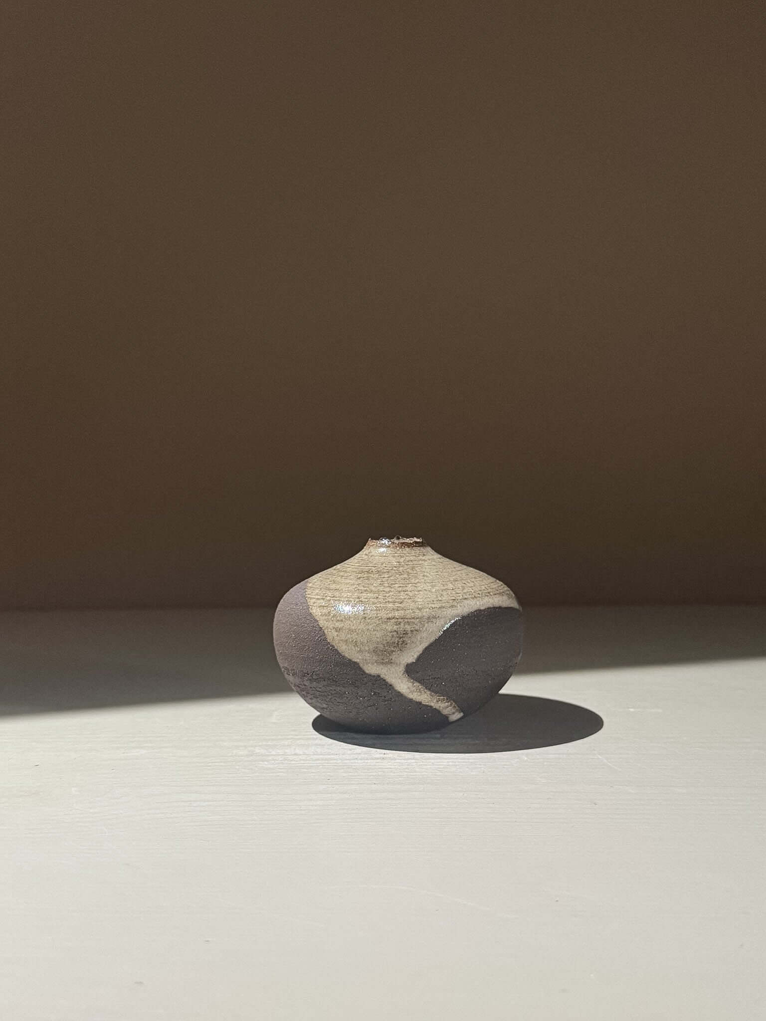 Orb Vase – Yuki Black #14 featuring rounded shape and unique glaze patterns, placed on a neutral background.