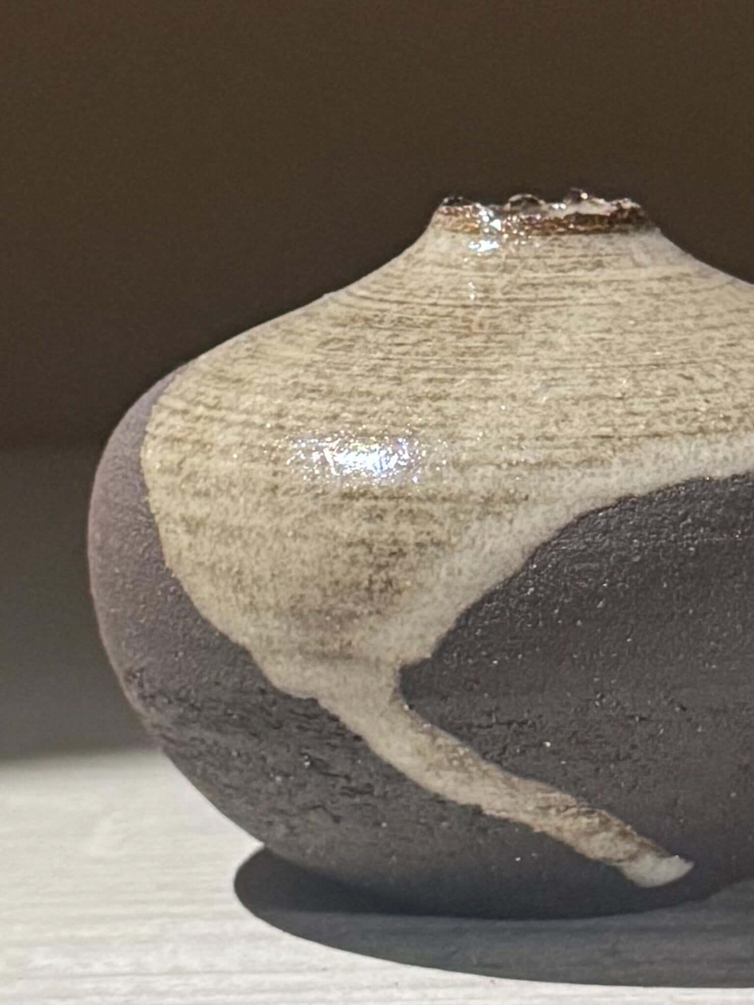 Close-up of Orb Vase – Yuki Black #14 showcasing its unique spherical form and organic glaze patterns.