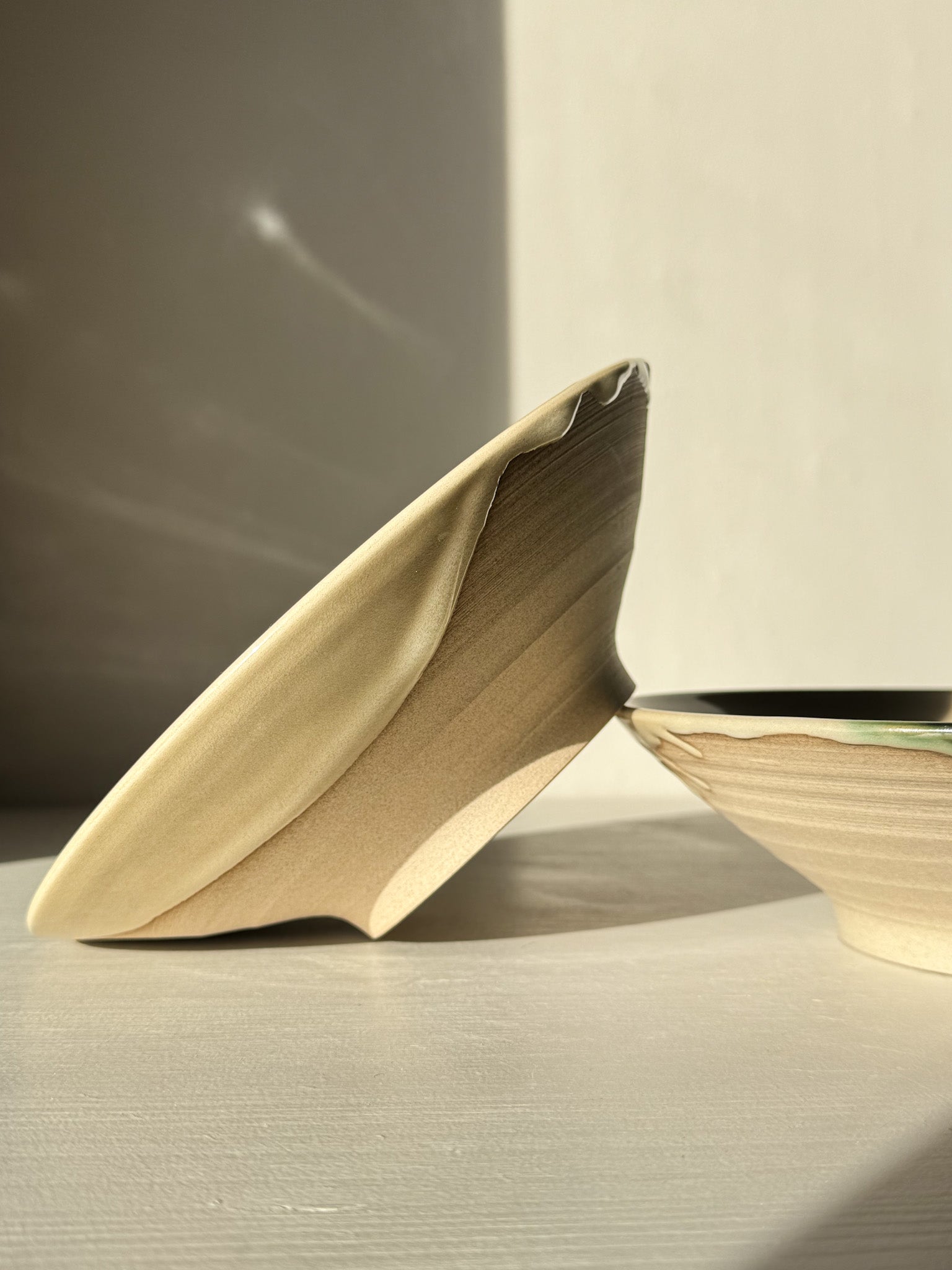 Side view of Salad/Pasta Plate – Mori with flowing green glaze and unglazed base, showcasing handcrafted stoneware uniqueness.