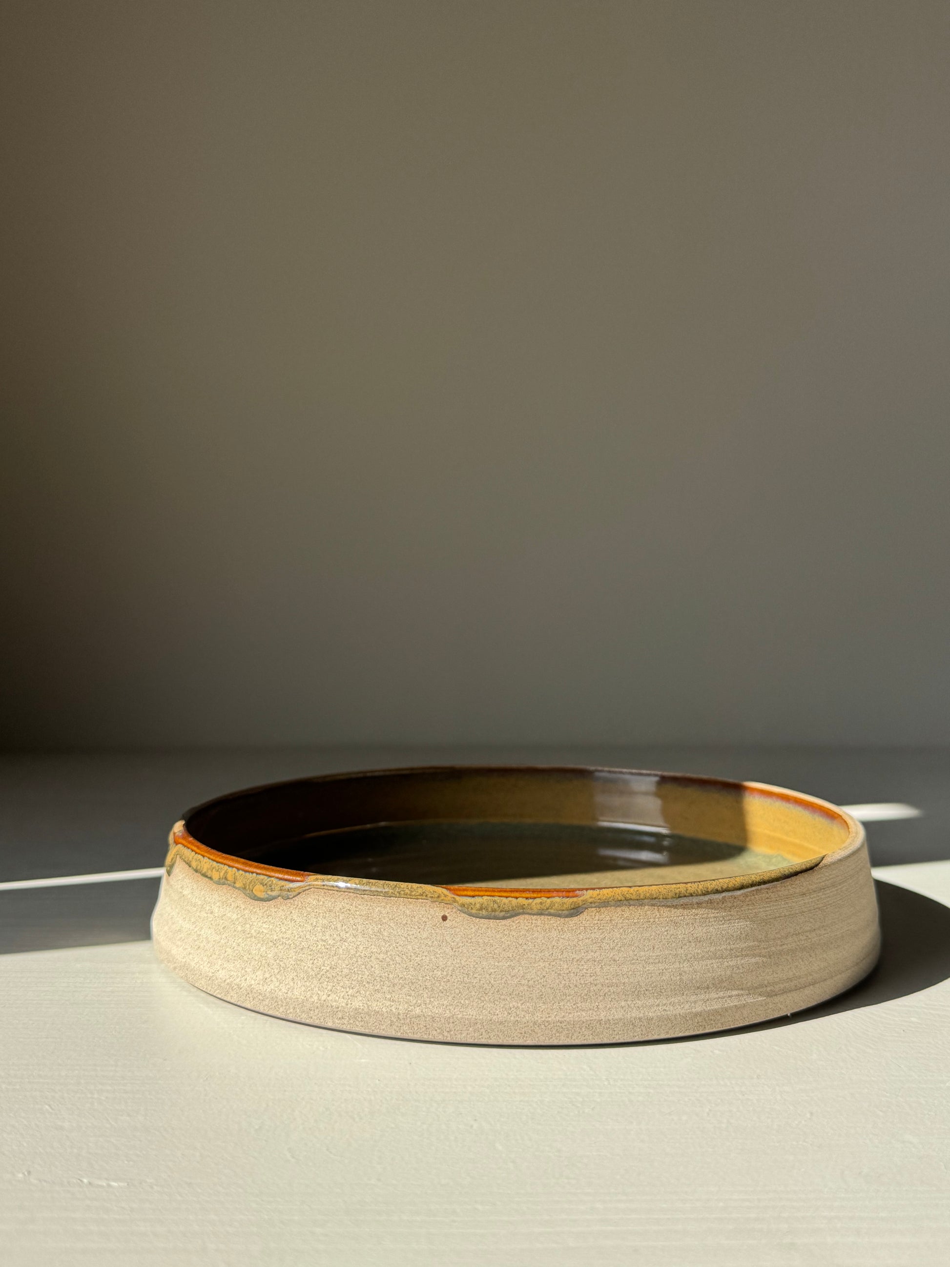 Plate – Inyo Series handmade ceramic with glossy tenmoku glaze and raw clay edge, showcasing unique design and versatility.