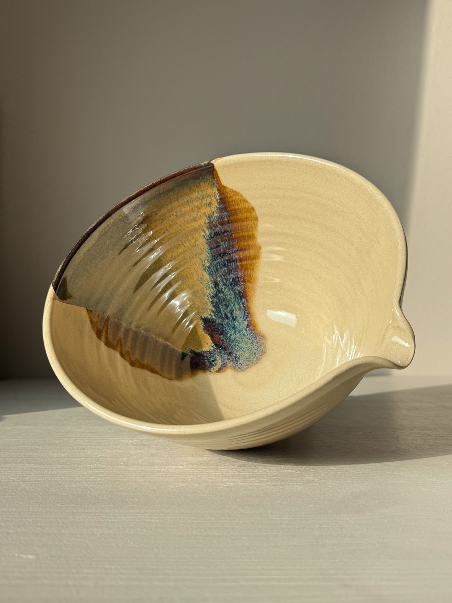 Pouring Bowl – Inyo with glossy tenmoku and clear glazes, showcasing sculptural design and smooth spout for functional use.