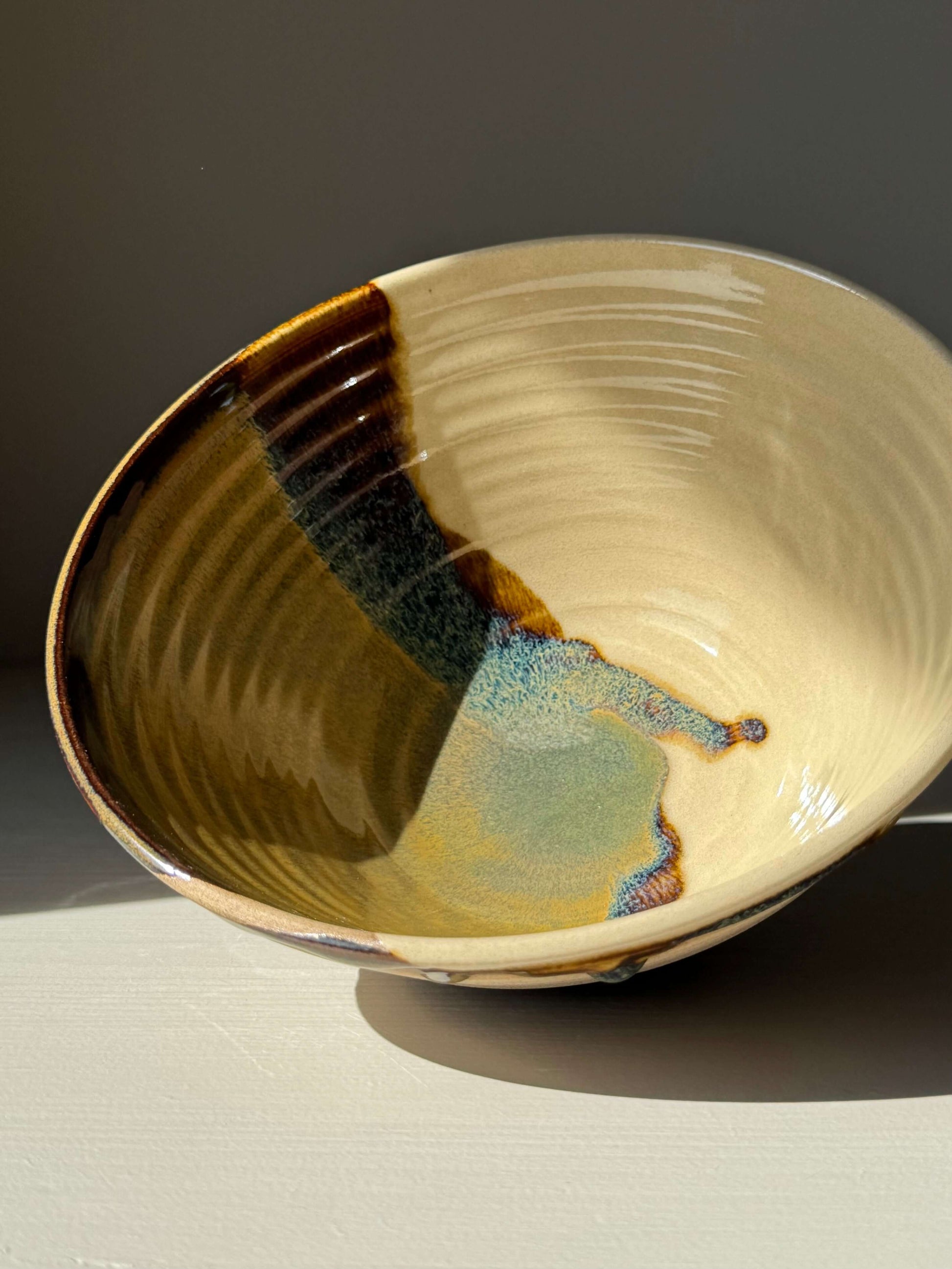 Handmade ceramic Ramen Bowl - Inyo Series with glossy tenmoku and clear glaze finish, showcasing a unique toffee clay surface.