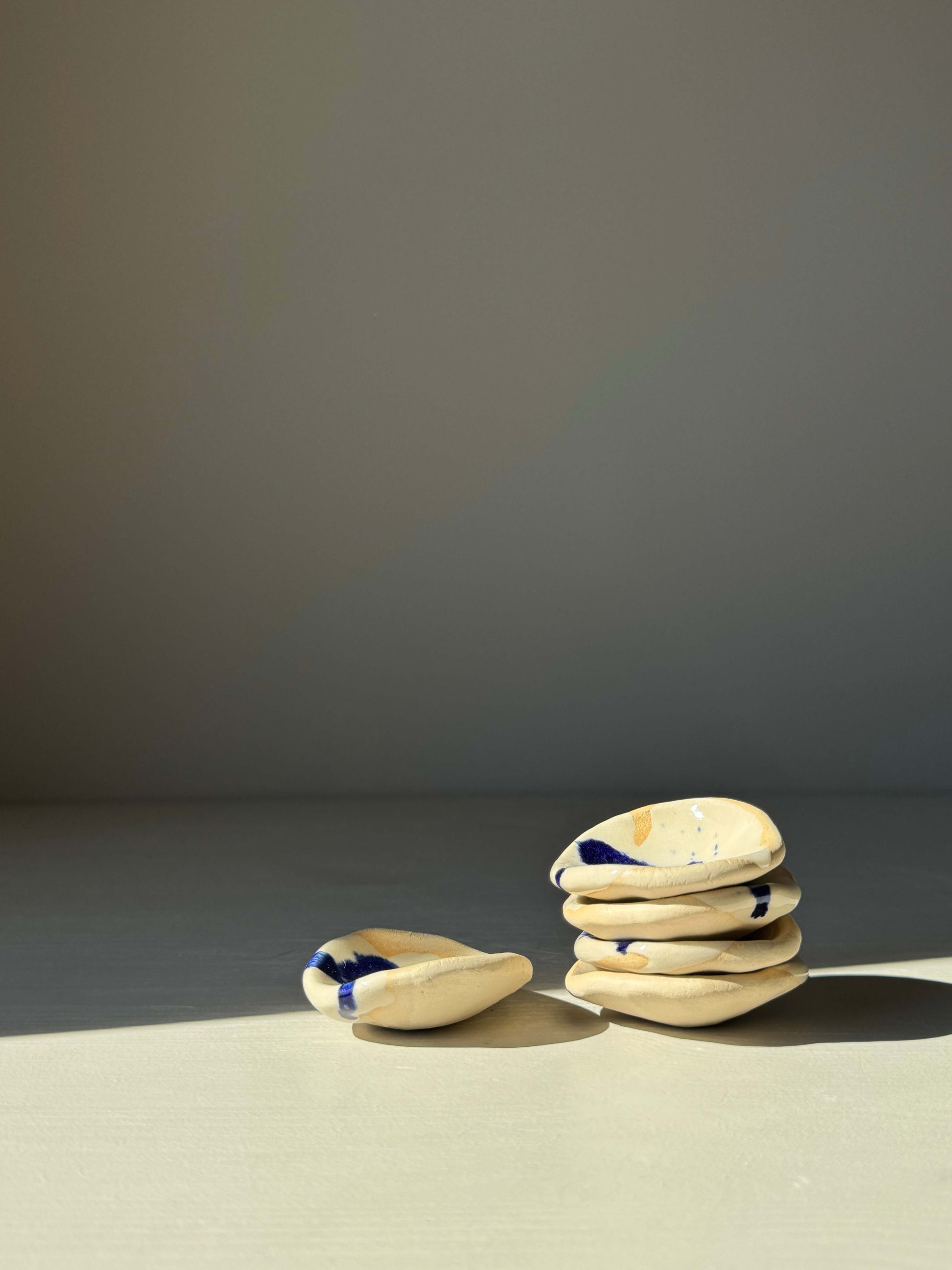 Round Chopstick/Spoon Rest – Gosu handmade ceramic holders with cobalt blue splashes stacked on a table.