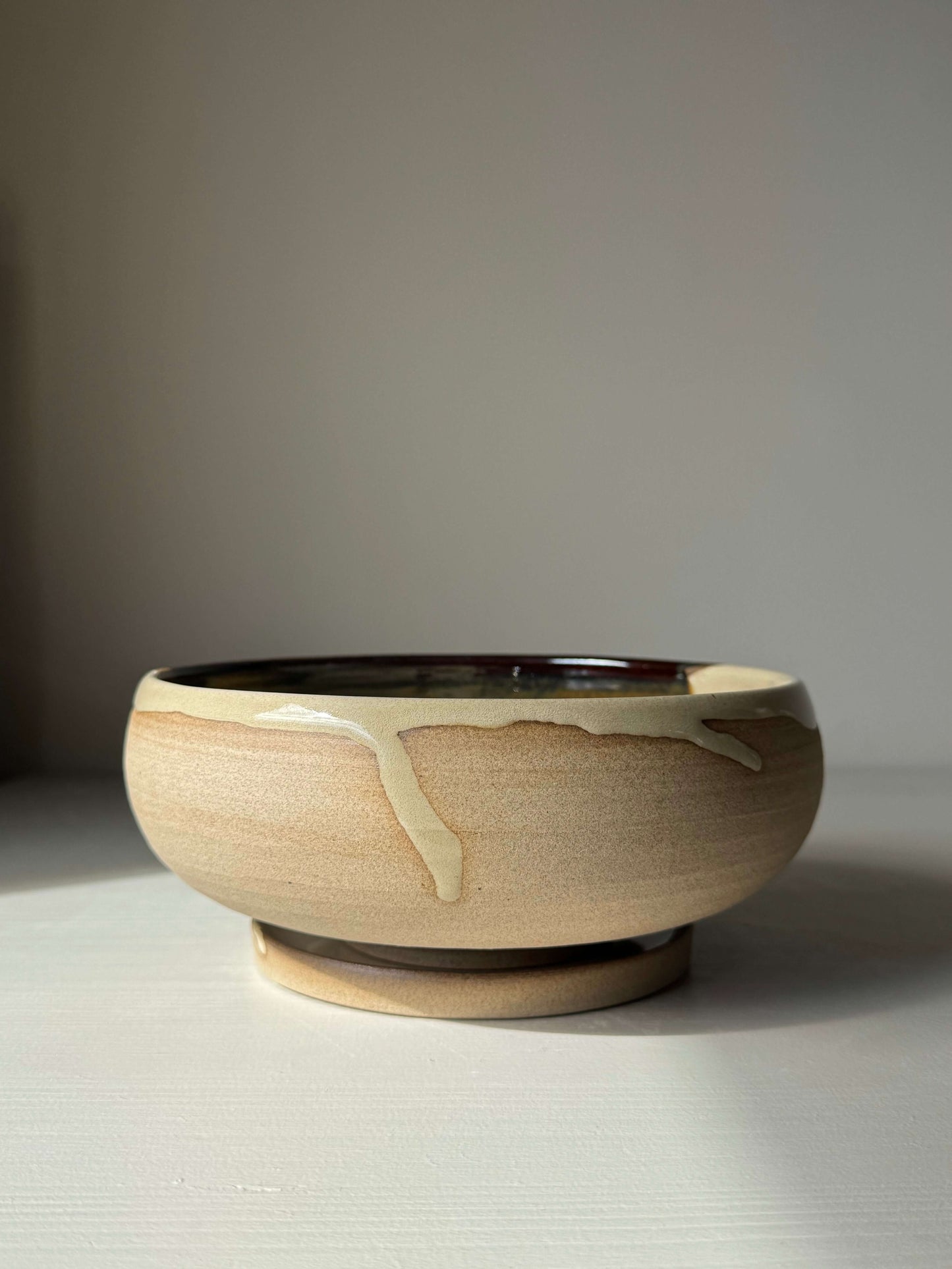 Rounded Berry Bowl - Inyo Series in handmade ceramic with glossy tenmoku glaze on a table.
