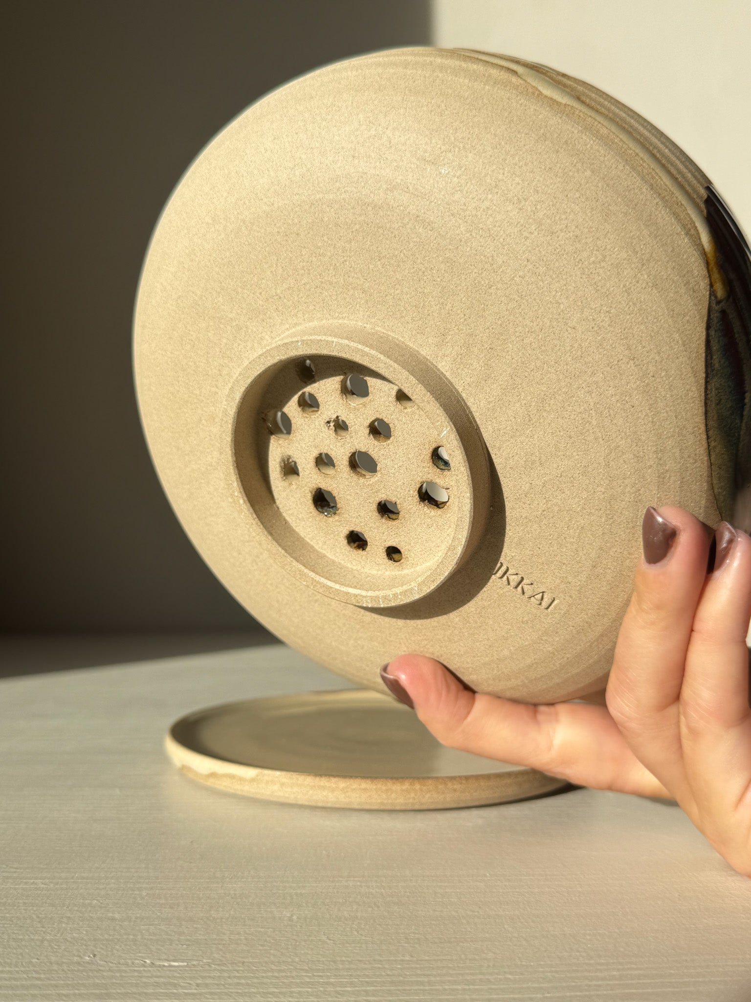 Rounded Berry Bowl - Inyo #01 showing underside details with drainage holes and matching drip plate in natural clay finish.