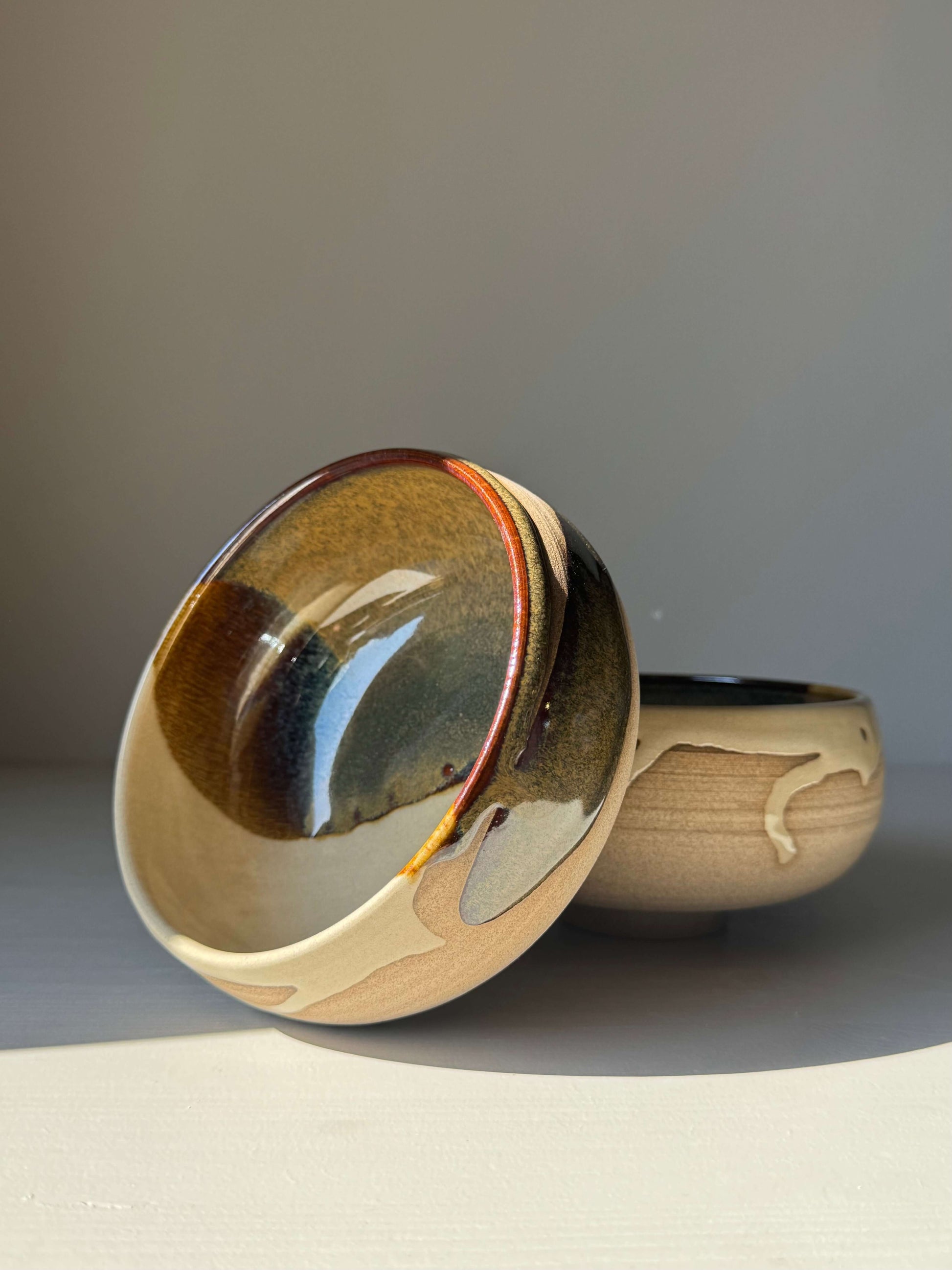 Rounded Breakfast Bowl – Inyo, handmade ceramic bowl with toffee colored clay and flowing clear and tenmoku glaze finish.