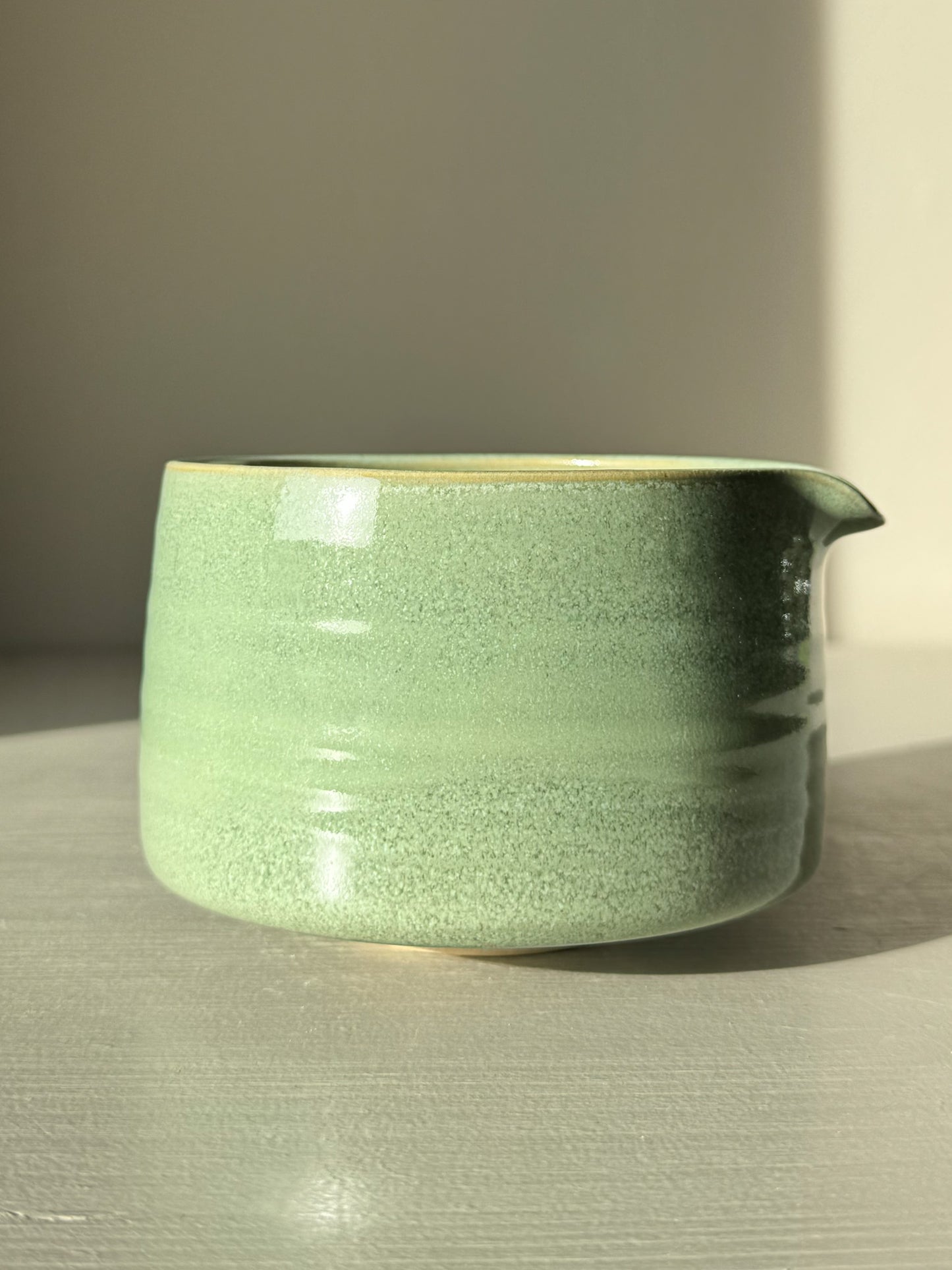 Matcha Bowl Spout – Sage #02 with sage-green glaze on a sunny surface, highlighting the smooth, open design perfect for whisking matcha.