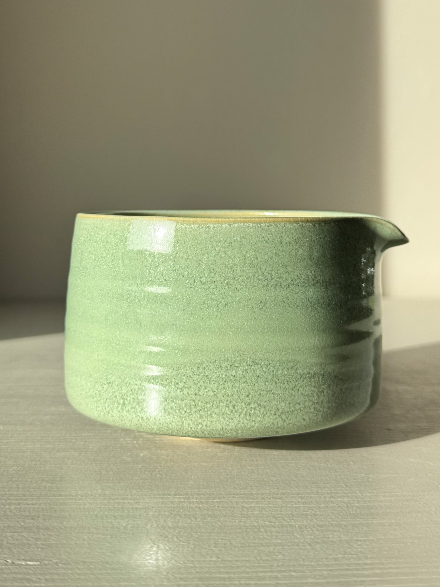 Matcha Bowl Spout – Sage #02 with sage-green glaze on a sunny surface, highlighting the smooth, open design perfect for whisking matcha.