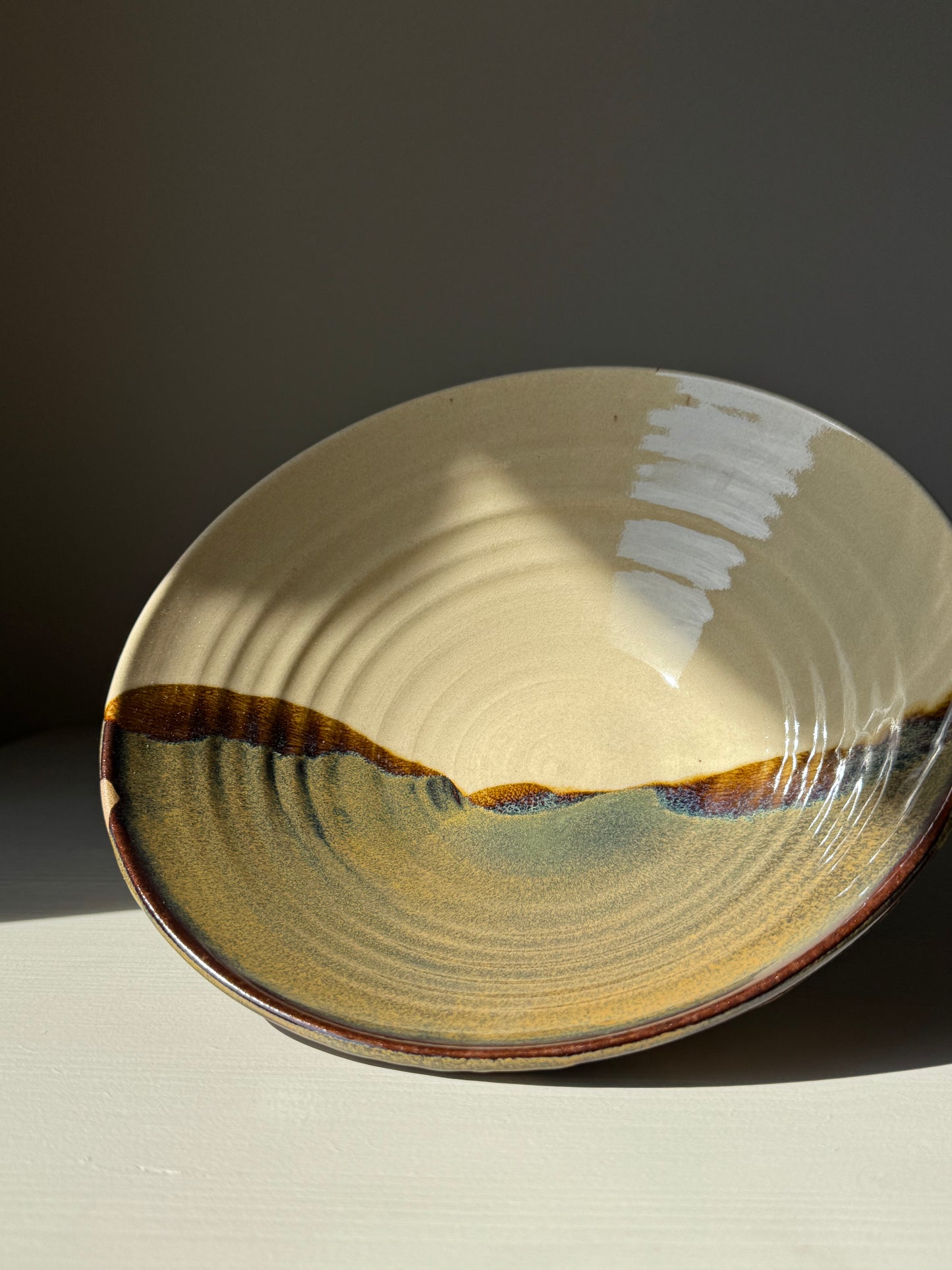 Salad/Pasta Plate – Inyo handmade ceramic bowl with flowing Tenmoku glaze accents, showcasing light and dark contrasts.