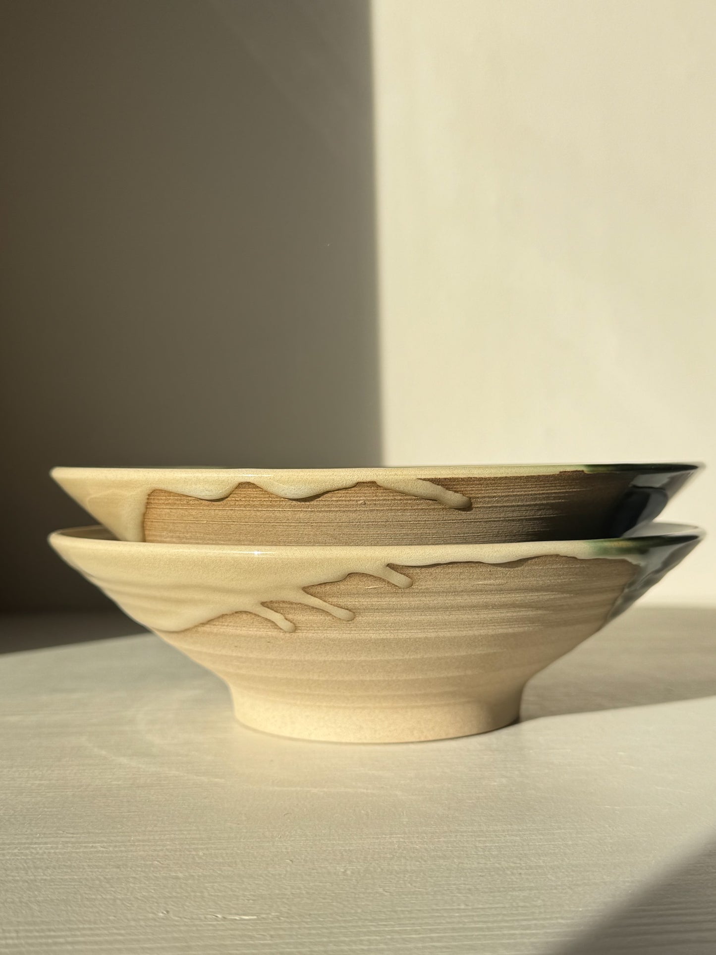 Stacked Mori Salad/Pasta Plates with flowing green glaze on stoneware