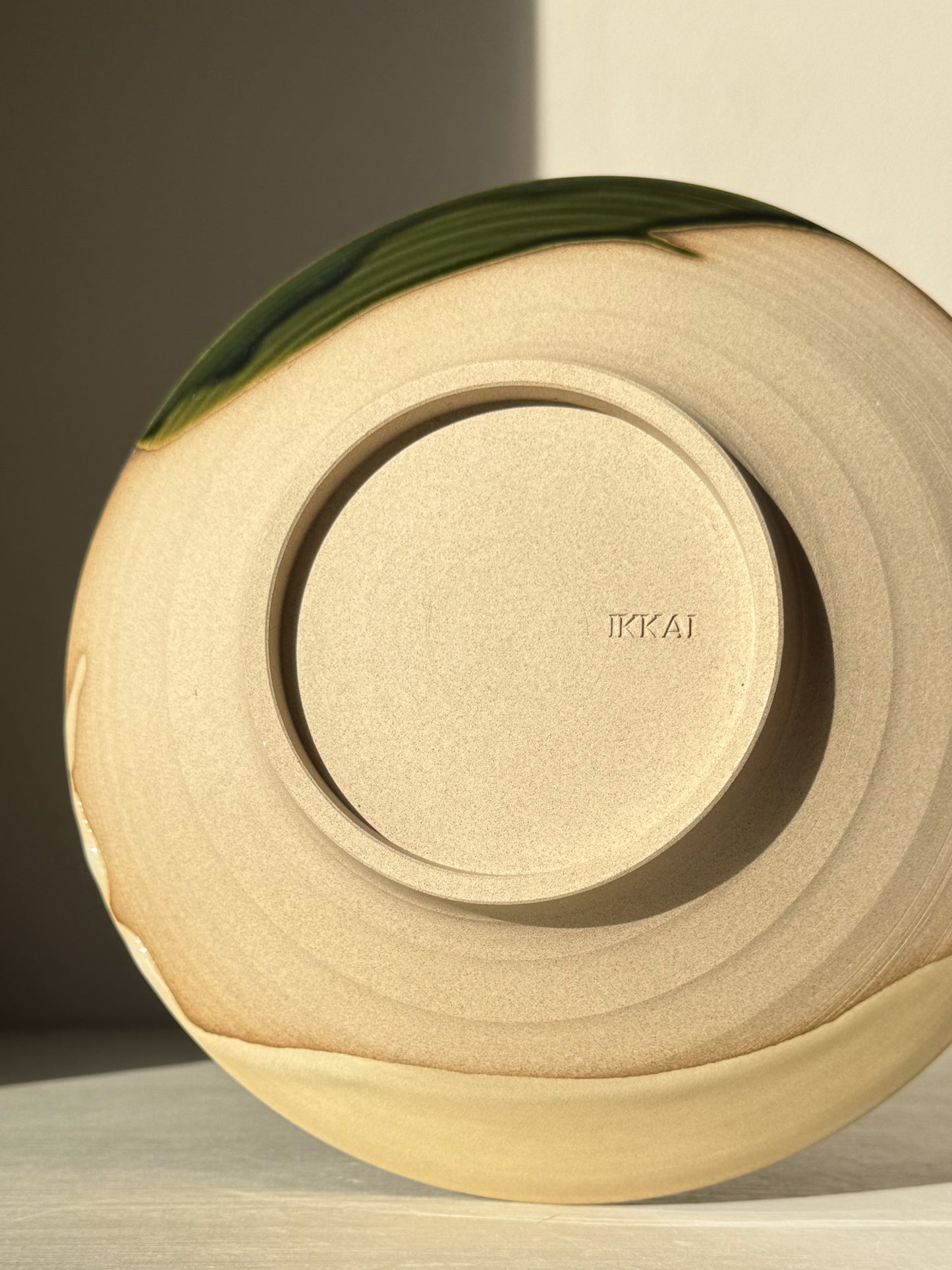 Back view of Salad/Pasta Plate – Mori with unglazed raw clay base, depicting wheel-thrown stoneware and gentle green glaze accents.