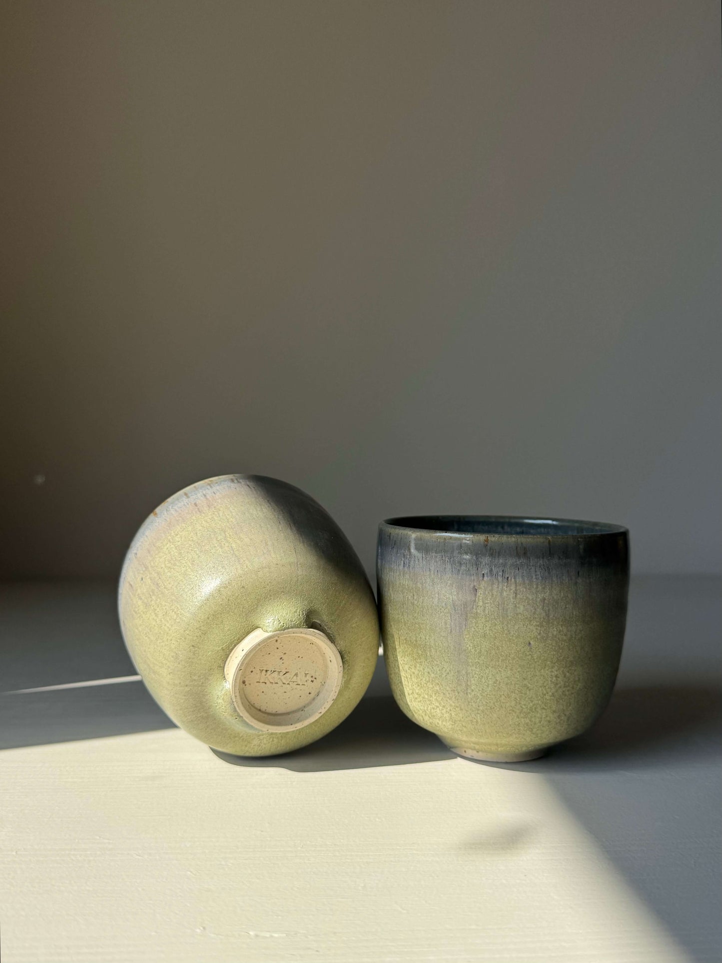 Cups - Satin Blue handmade ceramic, featuring a wheel-thrown rounded form with soft satin blue glaze and misty grey to olive green shifts.