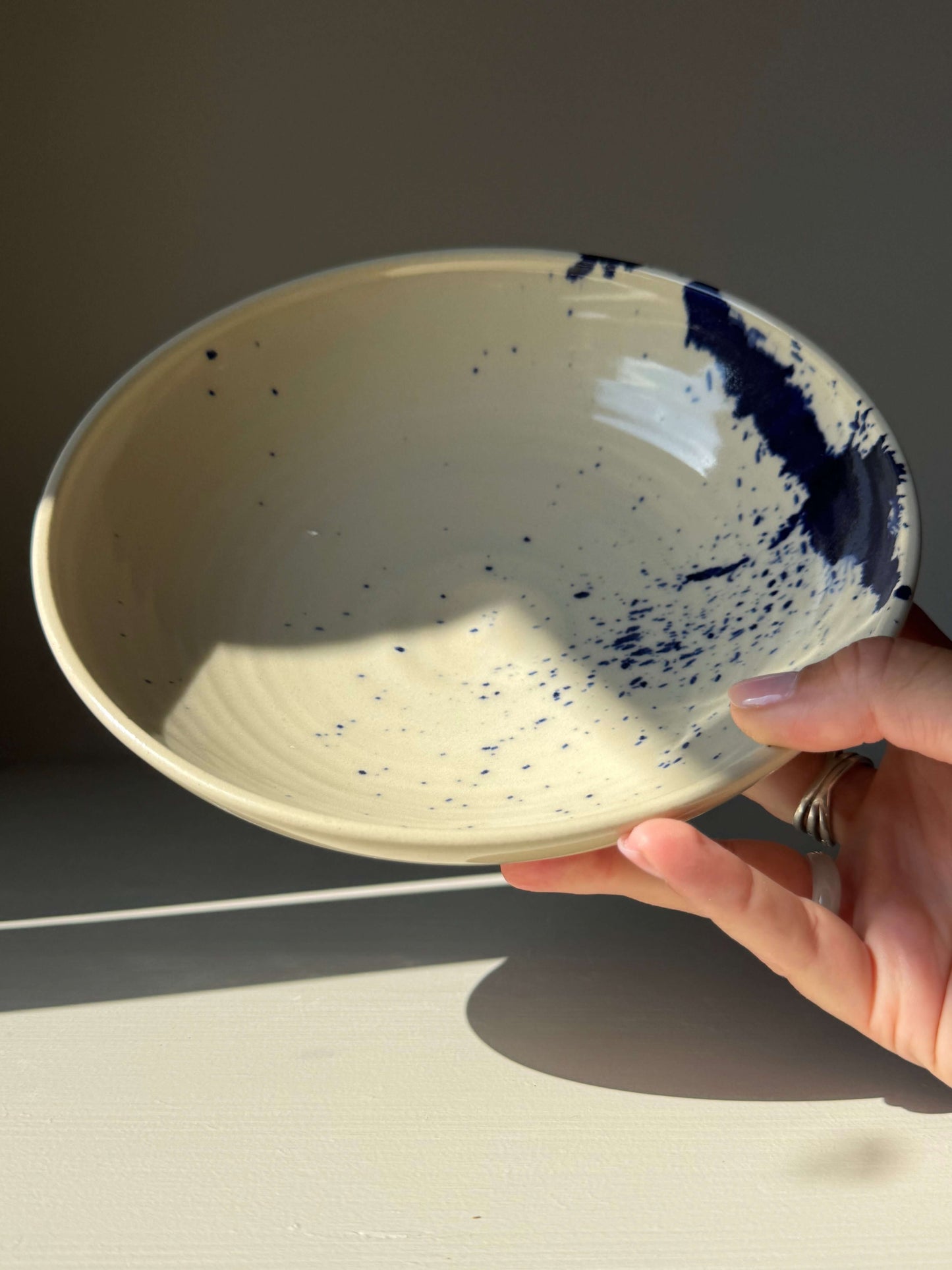 Shallow Dish - Gosu Series handmade ceramic with cobalt splashes, showing a side view of the stoneware bowl with a clear glaze finish.