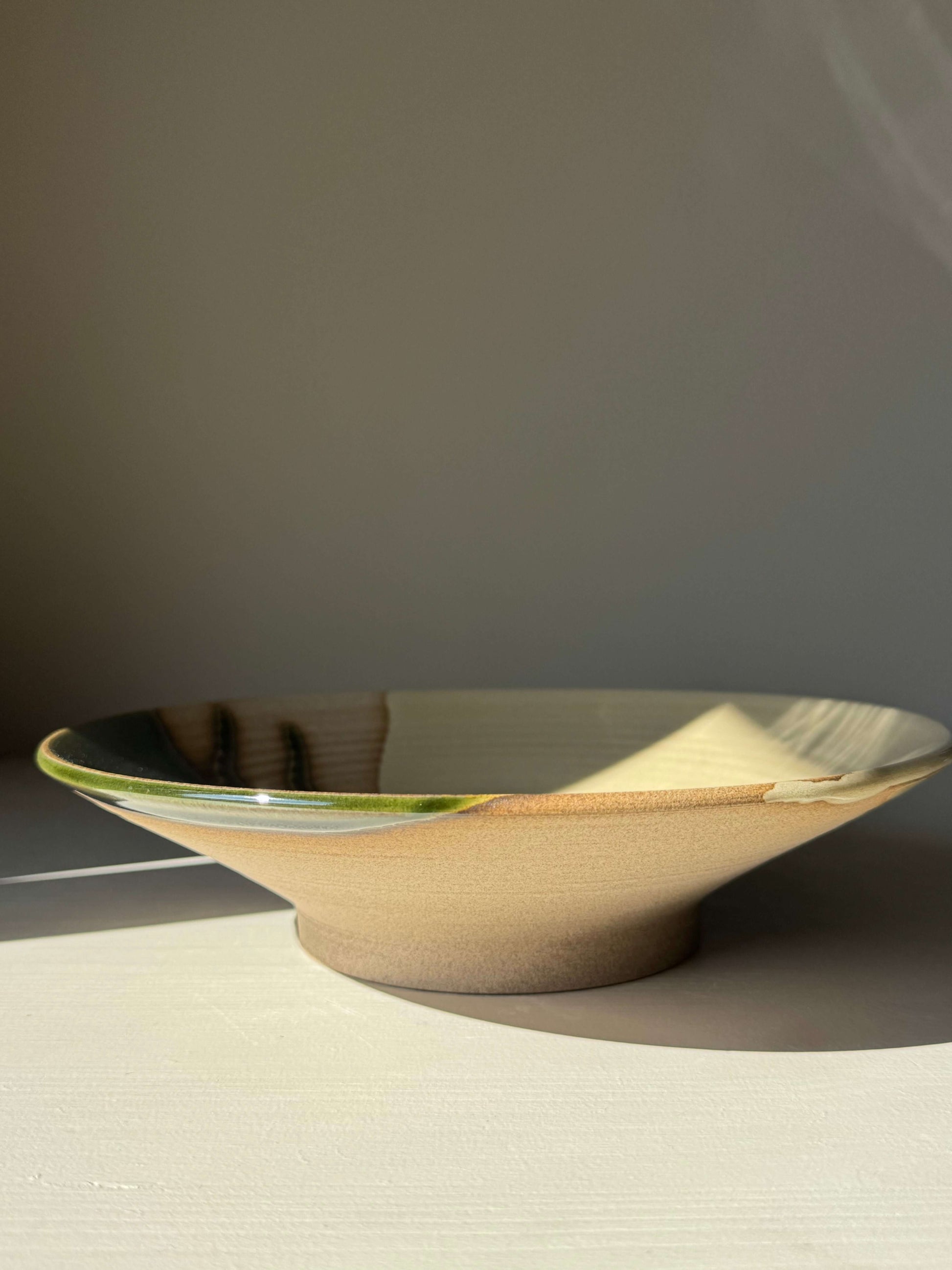 Shallow Plate – Mori handmade ceramic plate featuring glossy forest-green and blue hues on a wide, shallow form with raw clay base.