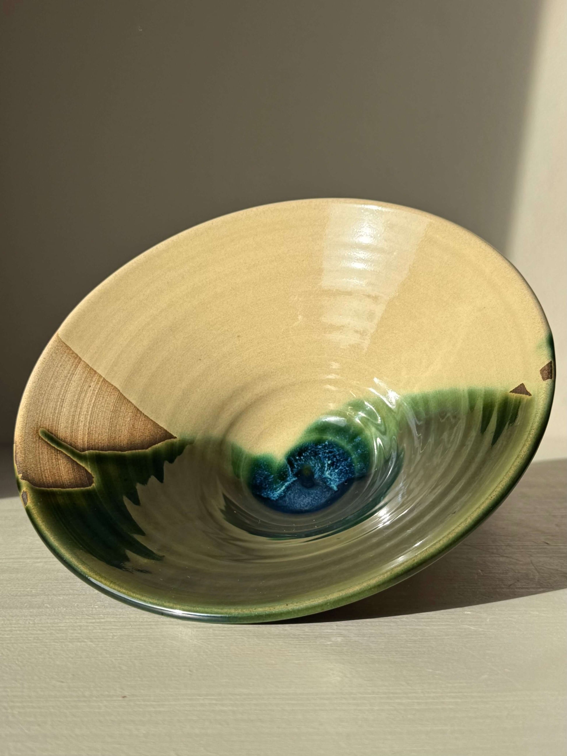 Small Serving Bowl - Mori #01 with glossy green glaze, handmade ceramic featuring natural tones and a blue burst at the center.