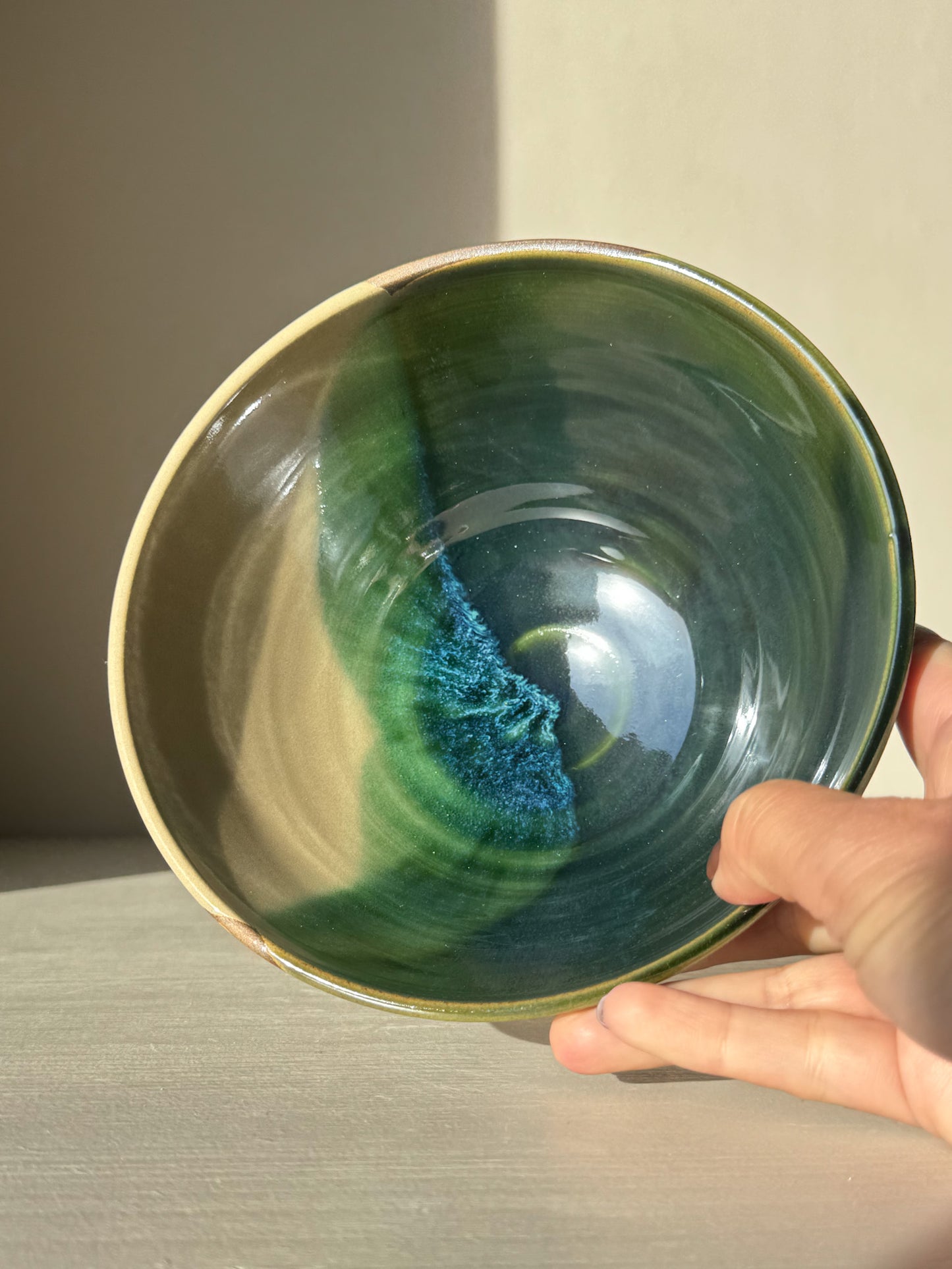 Hand holding a Soup Bowl – Mori Series with unique green glaze inside, showcasing handcrafted stoneware design.