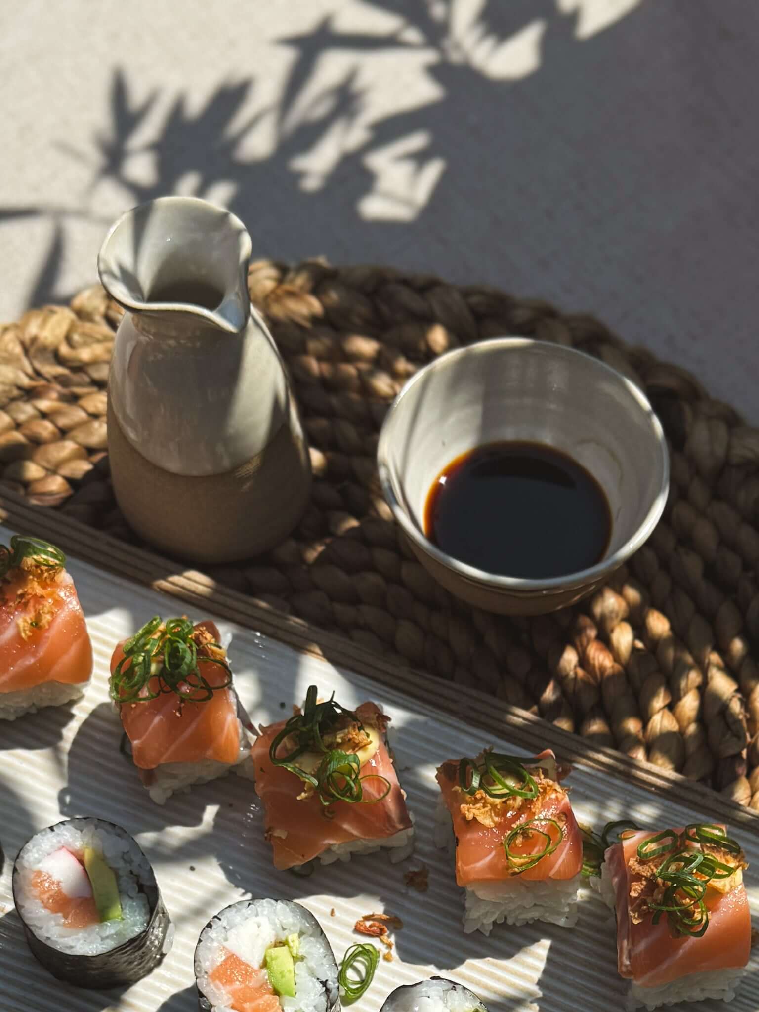 Soya Pourer - Yuki handmade ceramic pourer with sushi and soy sauce on a woven mat, showcasing elegant table setting.