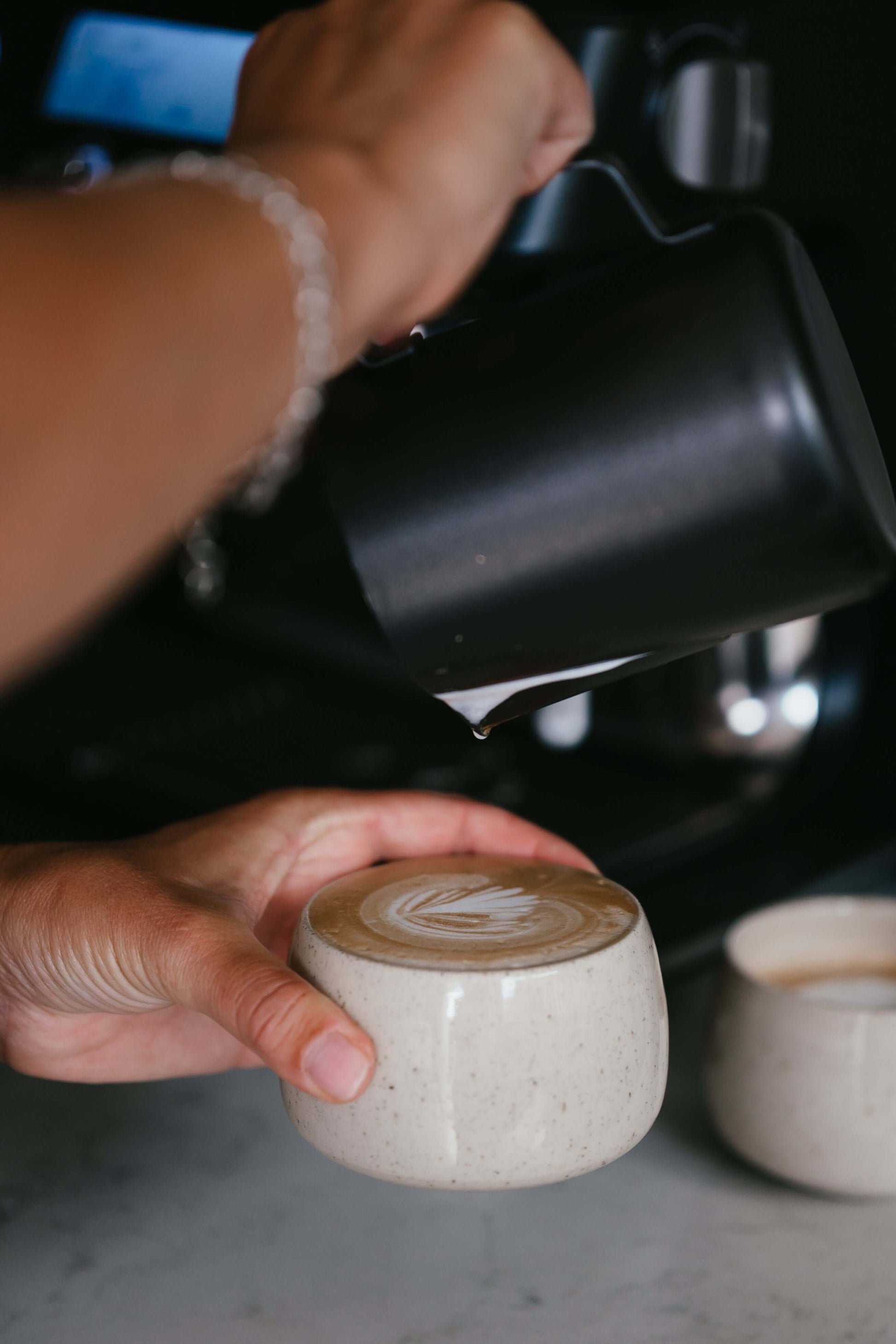 Pouring latte art into handmade ceramic Cups - Speckled Clear Glaze on a quiet morning.