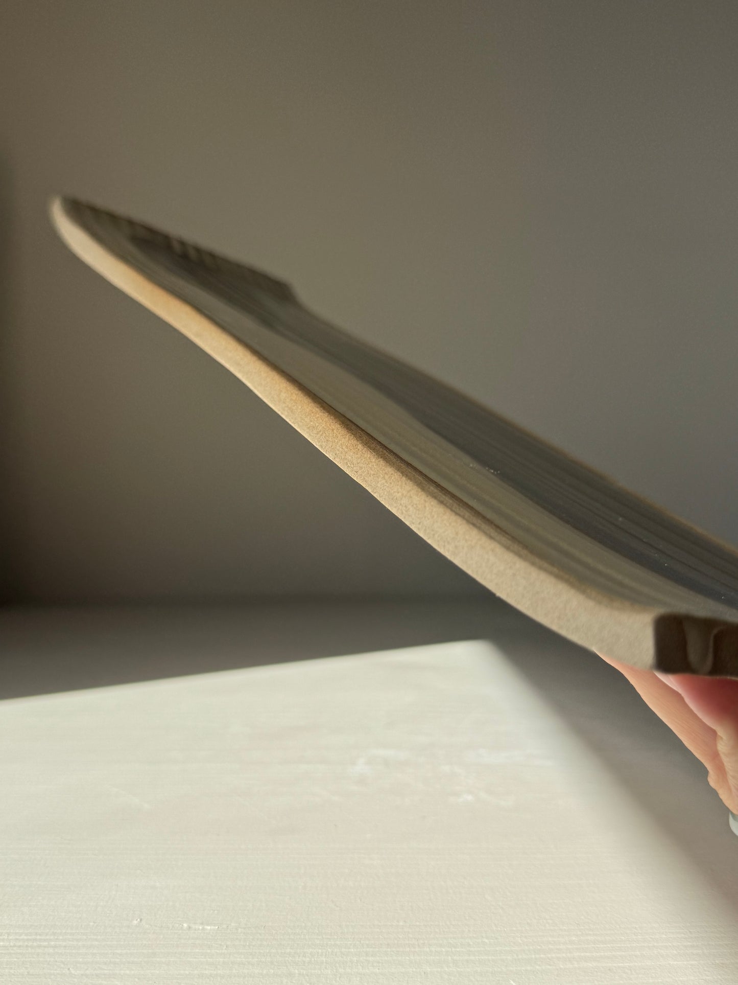 Side view of handmade ceramic Sushi Plate – Inyo Series #01, showcasing its unique curved design and high-quality craftsmanship.