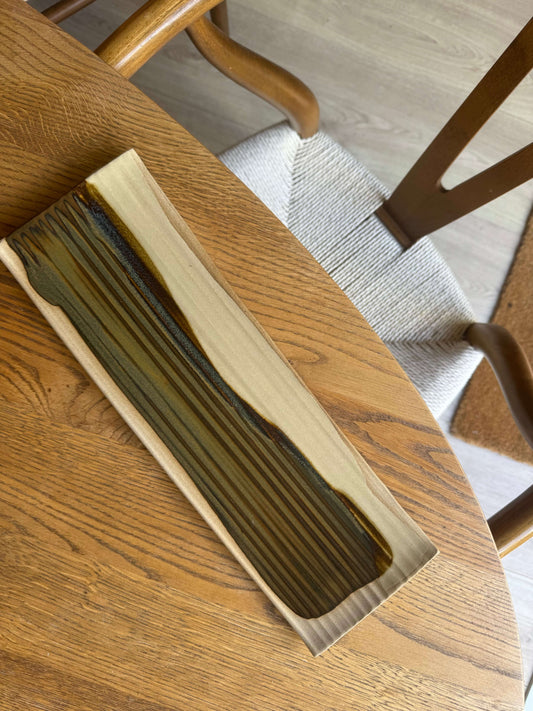 Sushi Plate – Inyo Series #03, handmade ceramic plate with unique tenmoku glaze, resting on a wooden table.