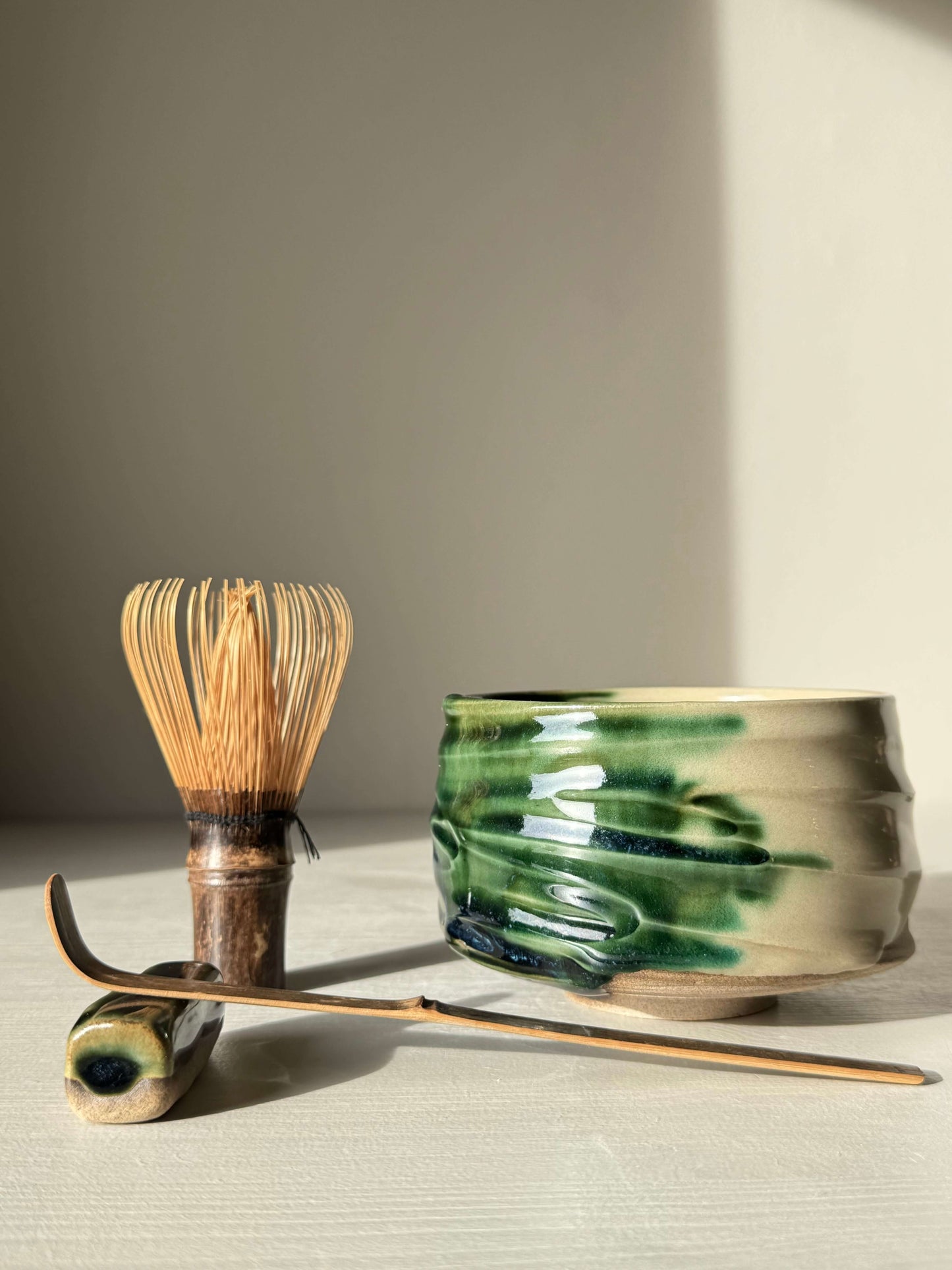 Textured Matcha Bowl – Mori #01 with handmade ceramic finish and green glaze, accompanied by a bamboo whisk and scoop