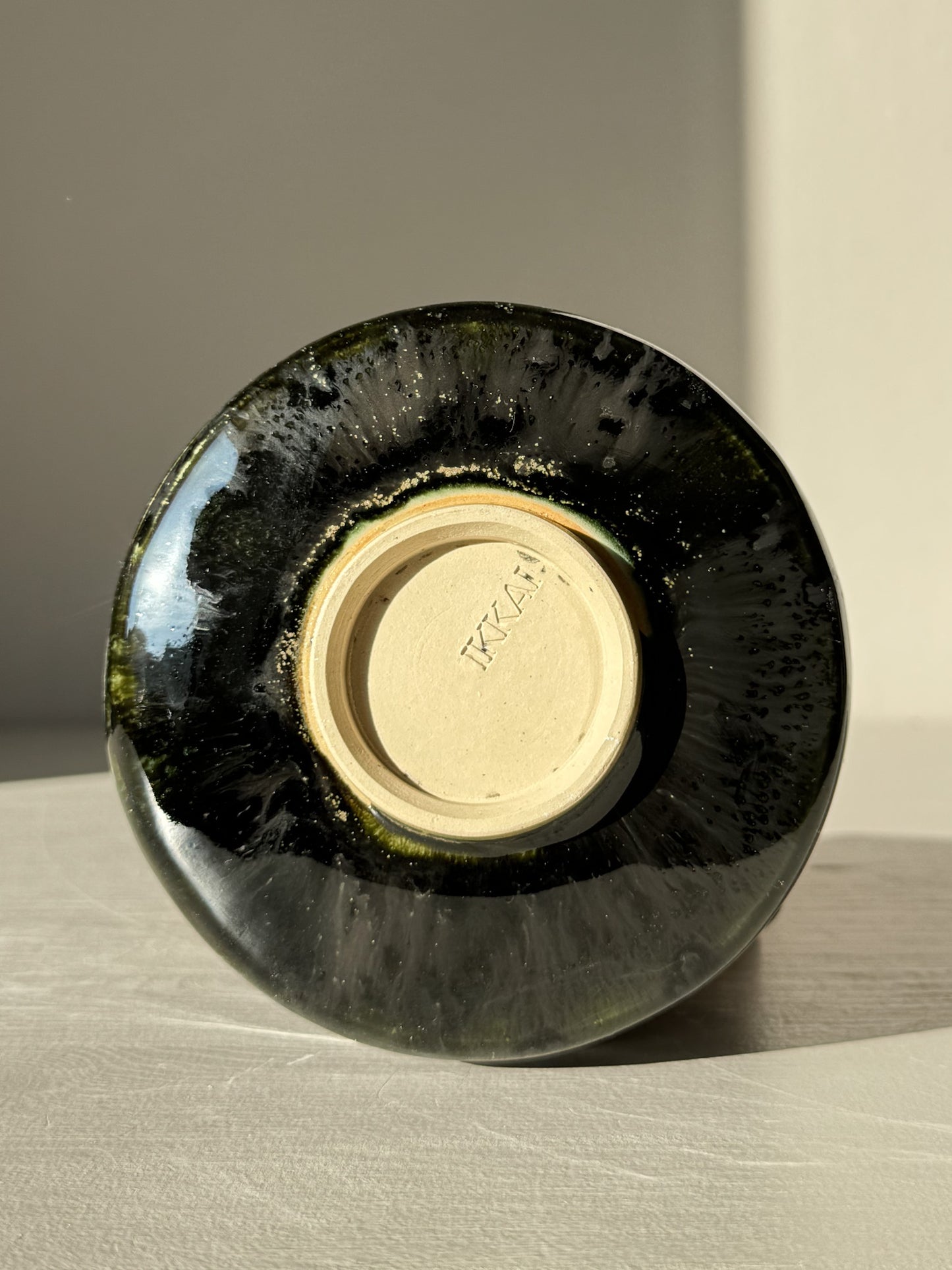 Underside view of Textured Matcha Bowl Spout - Hinoki #04 with glossy green glaze and signature, highlighting the craftsmanship details.