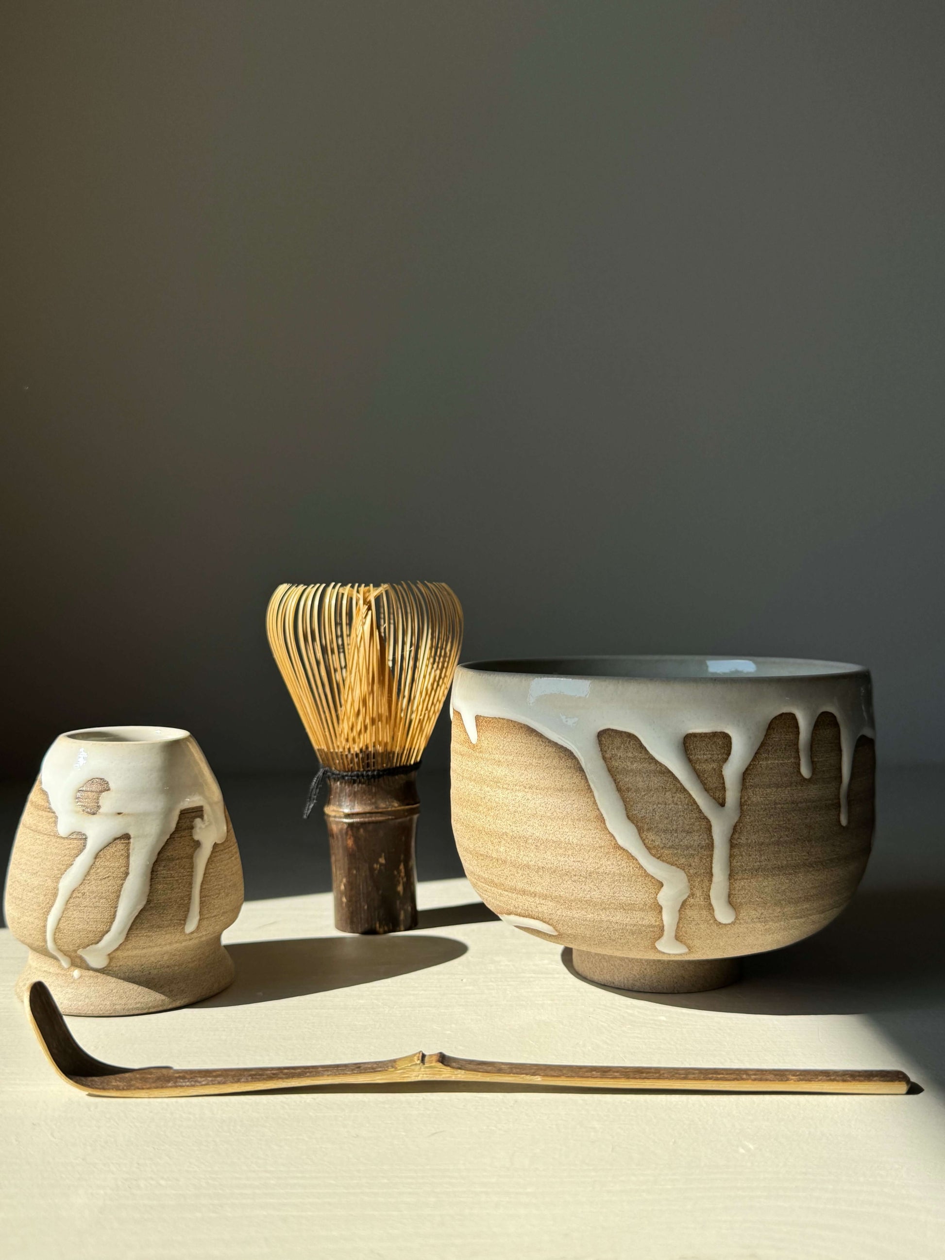 Handmade ceramic Whisk Holder - Yuki with bamboo whisk and matcha bowl, featuring glossy white glaze and natural toffee clay design.