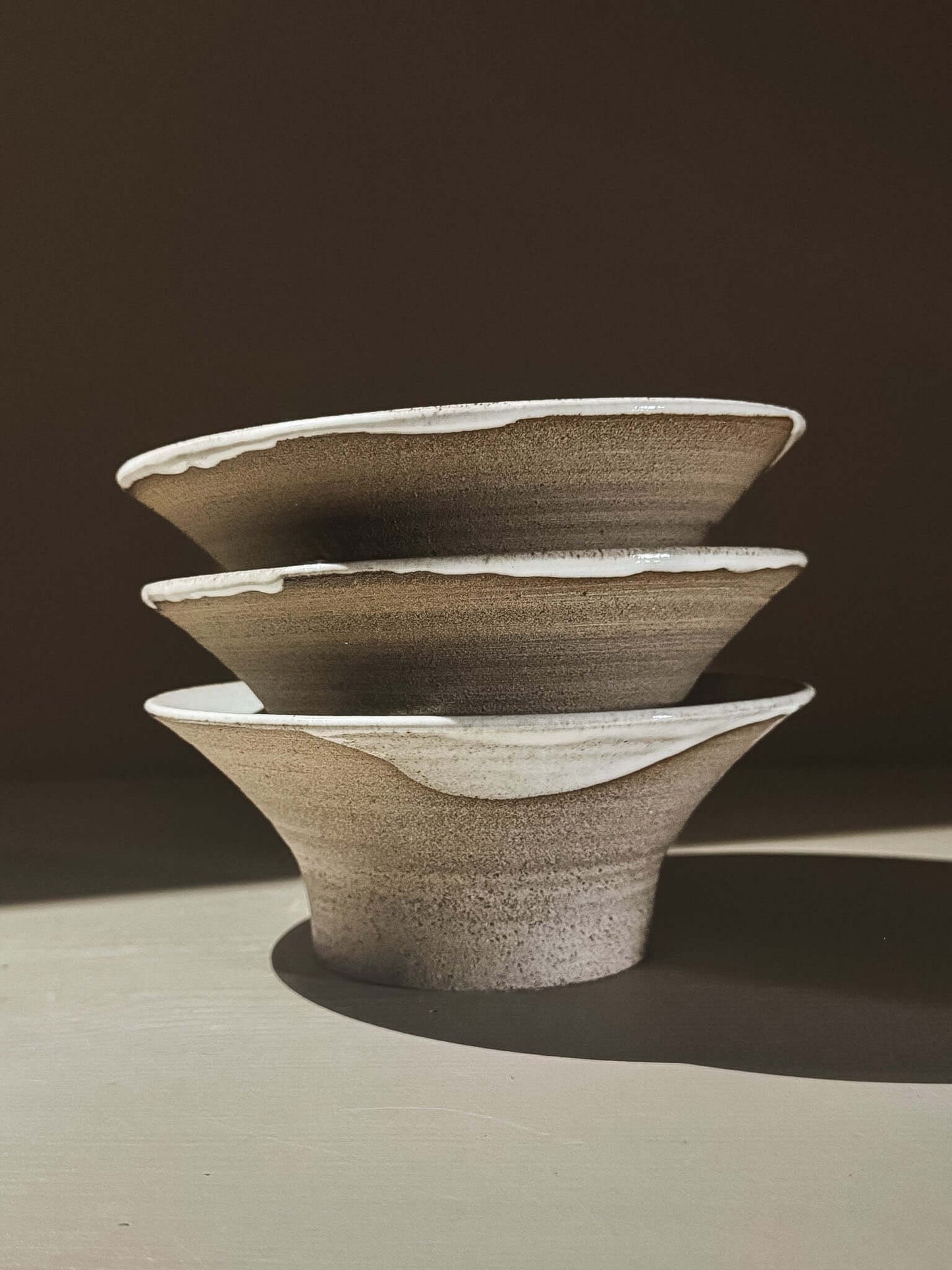 Bowl - Yuki Ash, handmade ceramic bowls with ash-grey clay and glossy white glaze, stacked in natural light.
