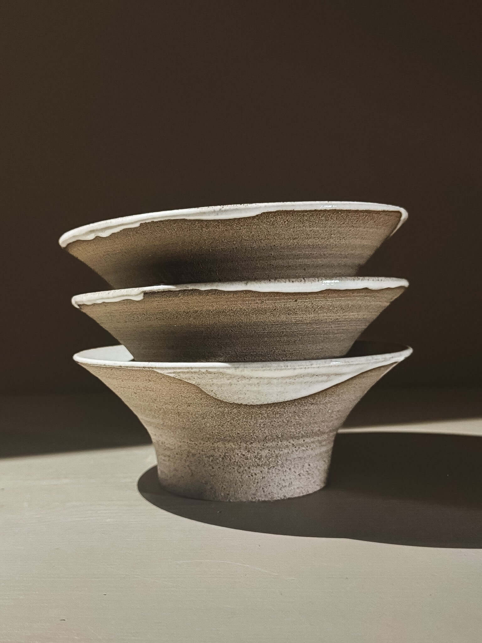Bowl - Yuki Ash, handmade ceramic bowls with ash-grey clay and glossy white glaze, stacked in natural light.