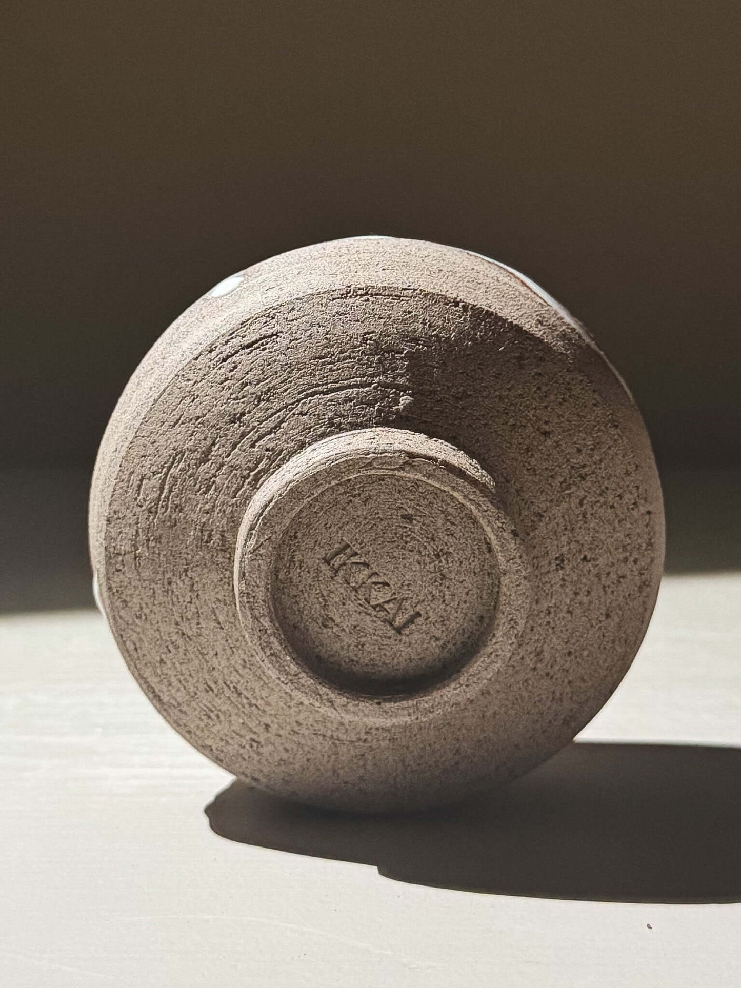 Yunomi Cup - Yuki Ash #02 showing the underside with textured clay and signature mark.