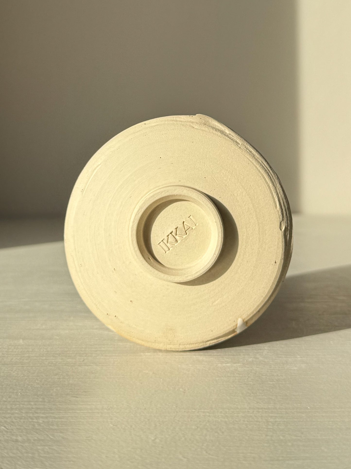 Underside view of Yunomi Cup – Glossy White #03 showing base design and glaze texture