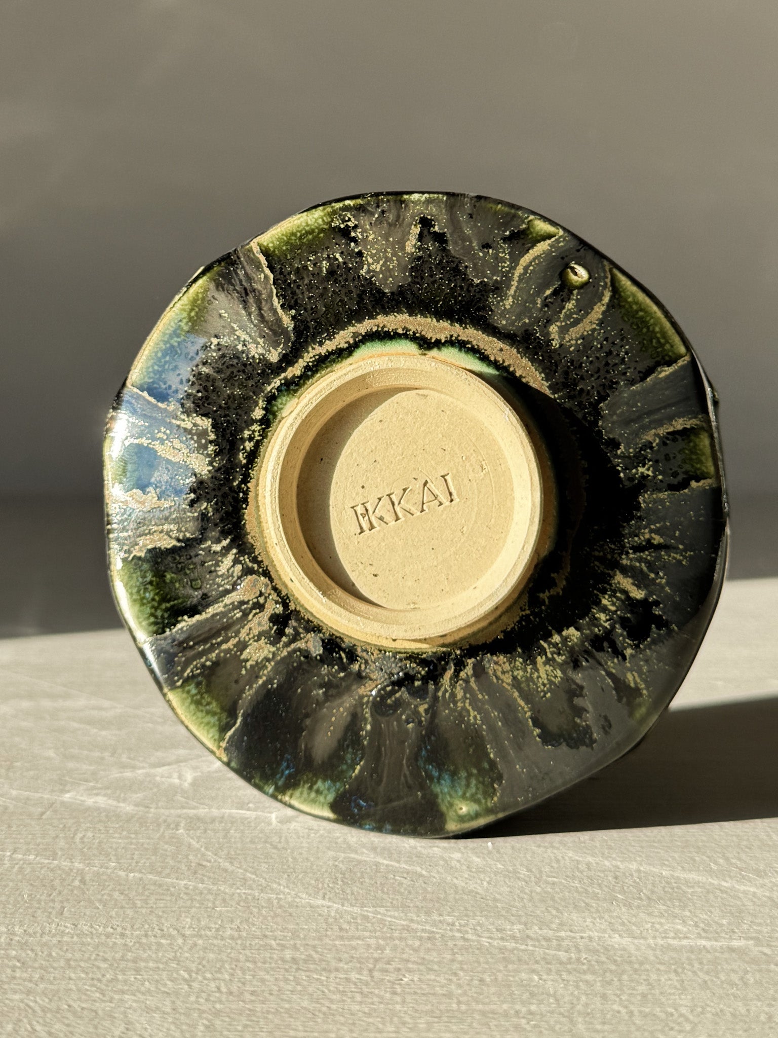 Bottom view of Yunomi Cup - Hinoki #04 with deep green glaze and unique hand-applied slip decoration.