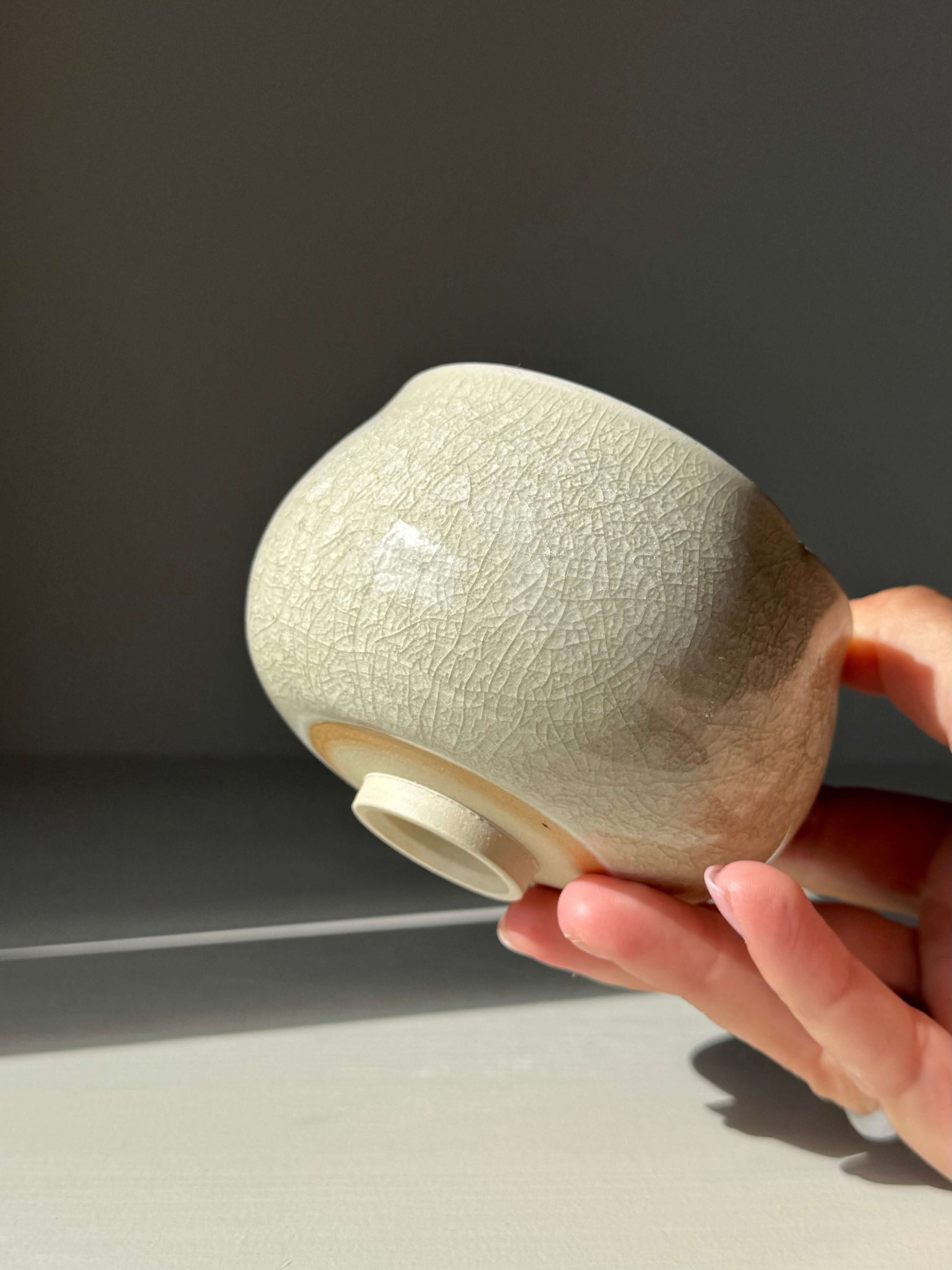 Close-up of handmade ceramic Yunomi Cup - Kannyū Series #12 with crackle glaze, showcasing unique patterns and elegant rim design.