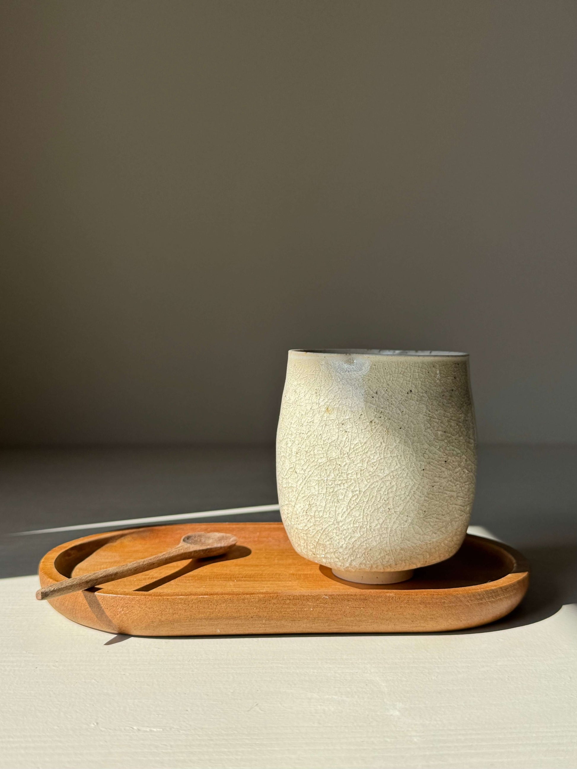 Yunomi Cup - Kannyū Series #07, handmade ceramic with crackle glaze, resting on a wooden tray.