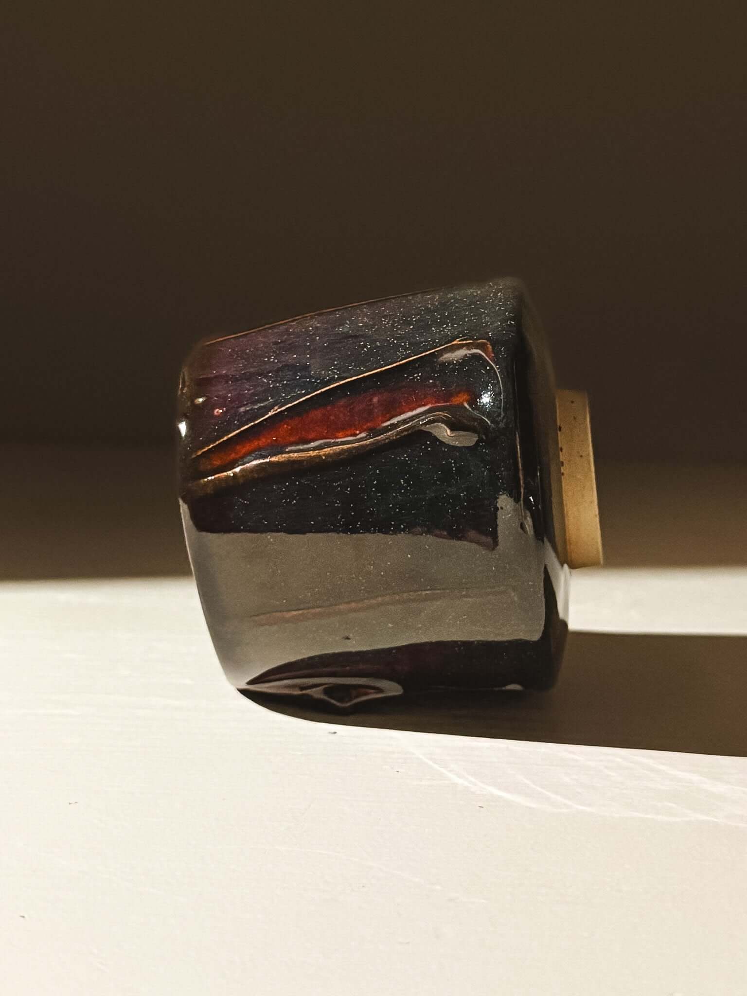 Handmade Yunomi Cup - Kuro with glossy black glaze and deep blue, burgundy, and red highlights.