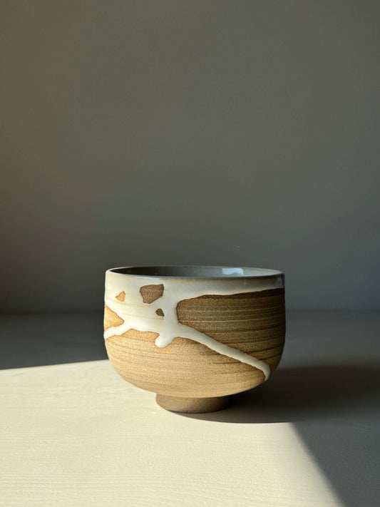 Handmade Matcha bowl from Yuki Series, featuring toffee clay and a flowing white glaze, creating a unique and calming aesthetic.