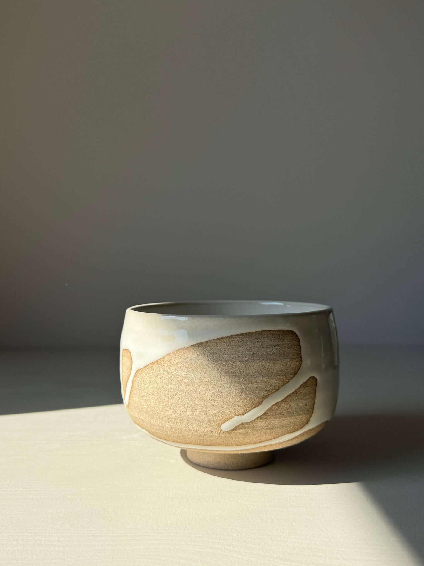 Handmade Matcha bowl from Yuki Series with toffee clay and white glaze, showcasing unique drip pattern, perfect for calming rituals.